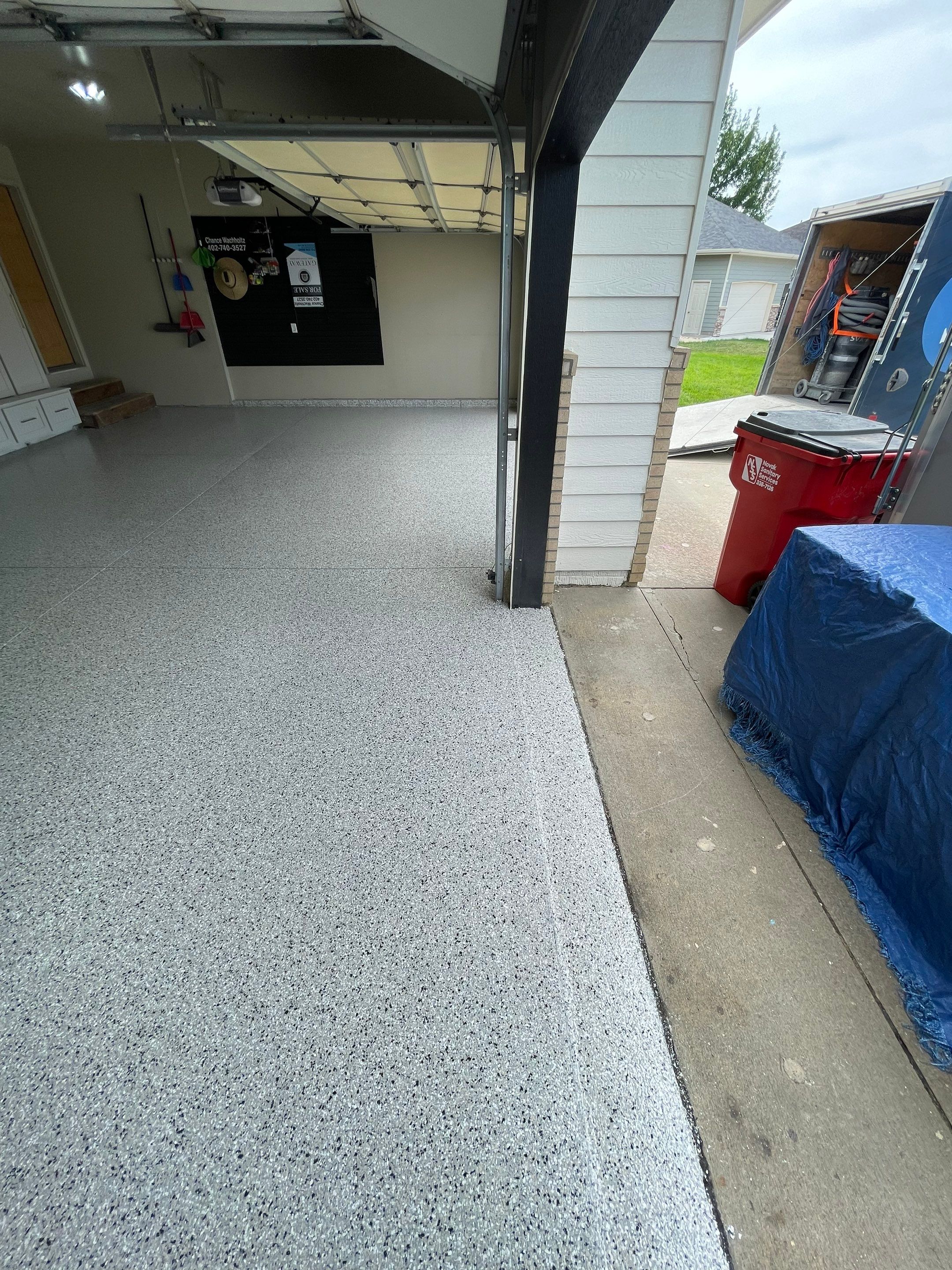 Cabin FEver Flake Garage Floor Coating Installation in Sioux Falls by Select Painting, Coatings & Garage Cabinets