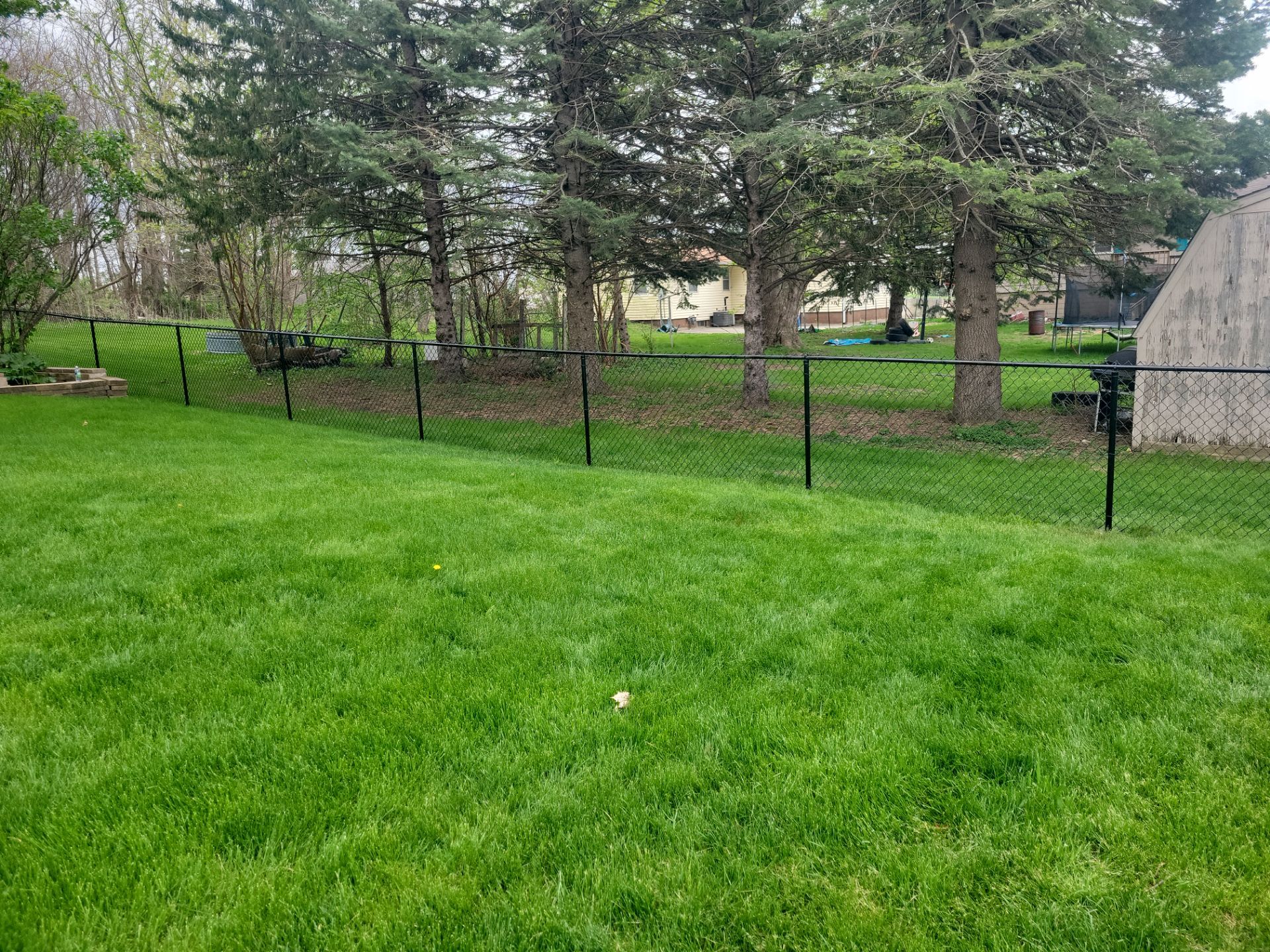 Residential Black Vinyl-Coated Chain Link Perimeter Fence in Garwin by Perfect Picket Fence and Stain