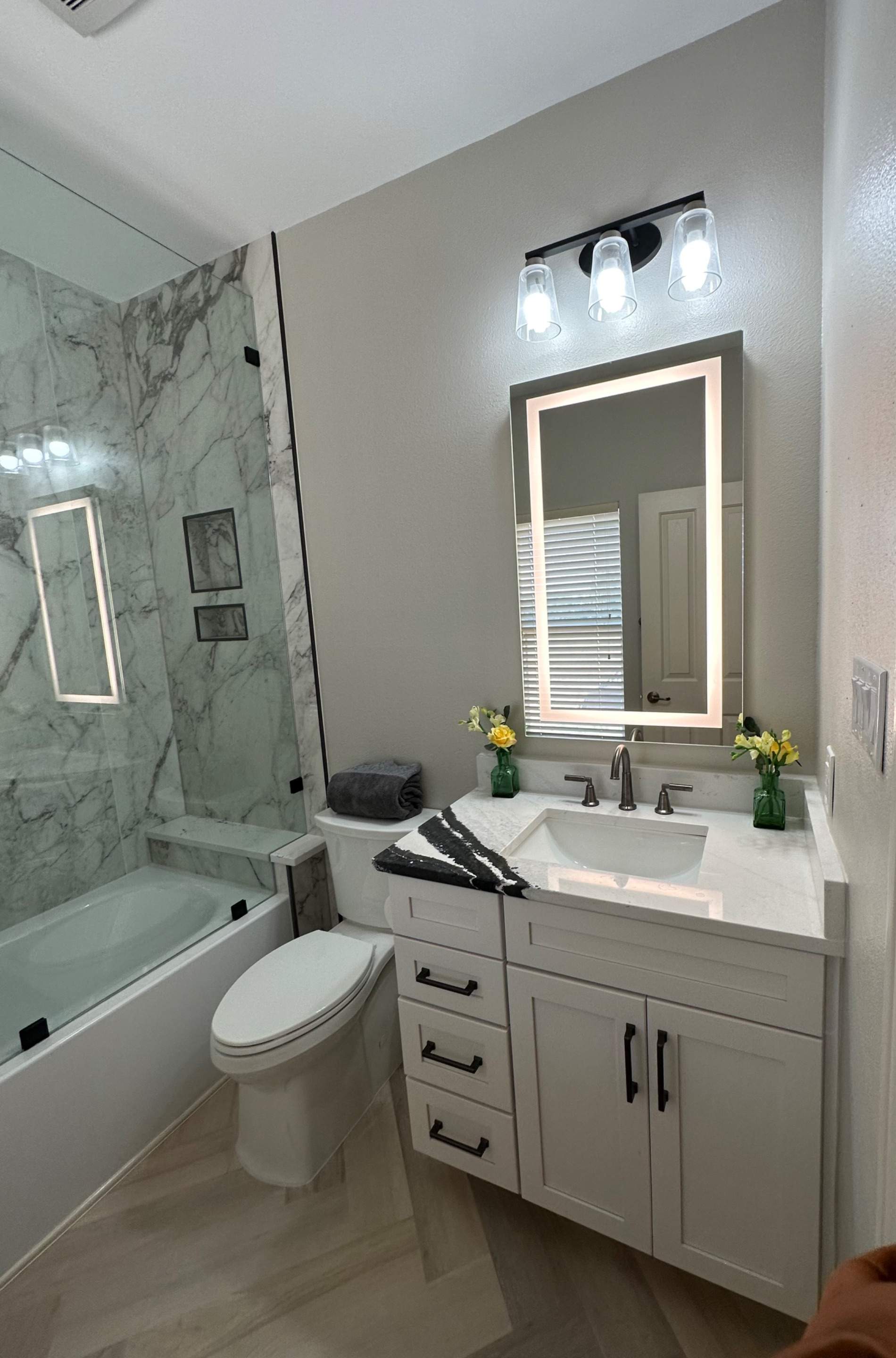 Boerne Guest Bathroom Remodel with Marble Tub Surround & Herringbone Flooring by Legacy Bath and Kitchen