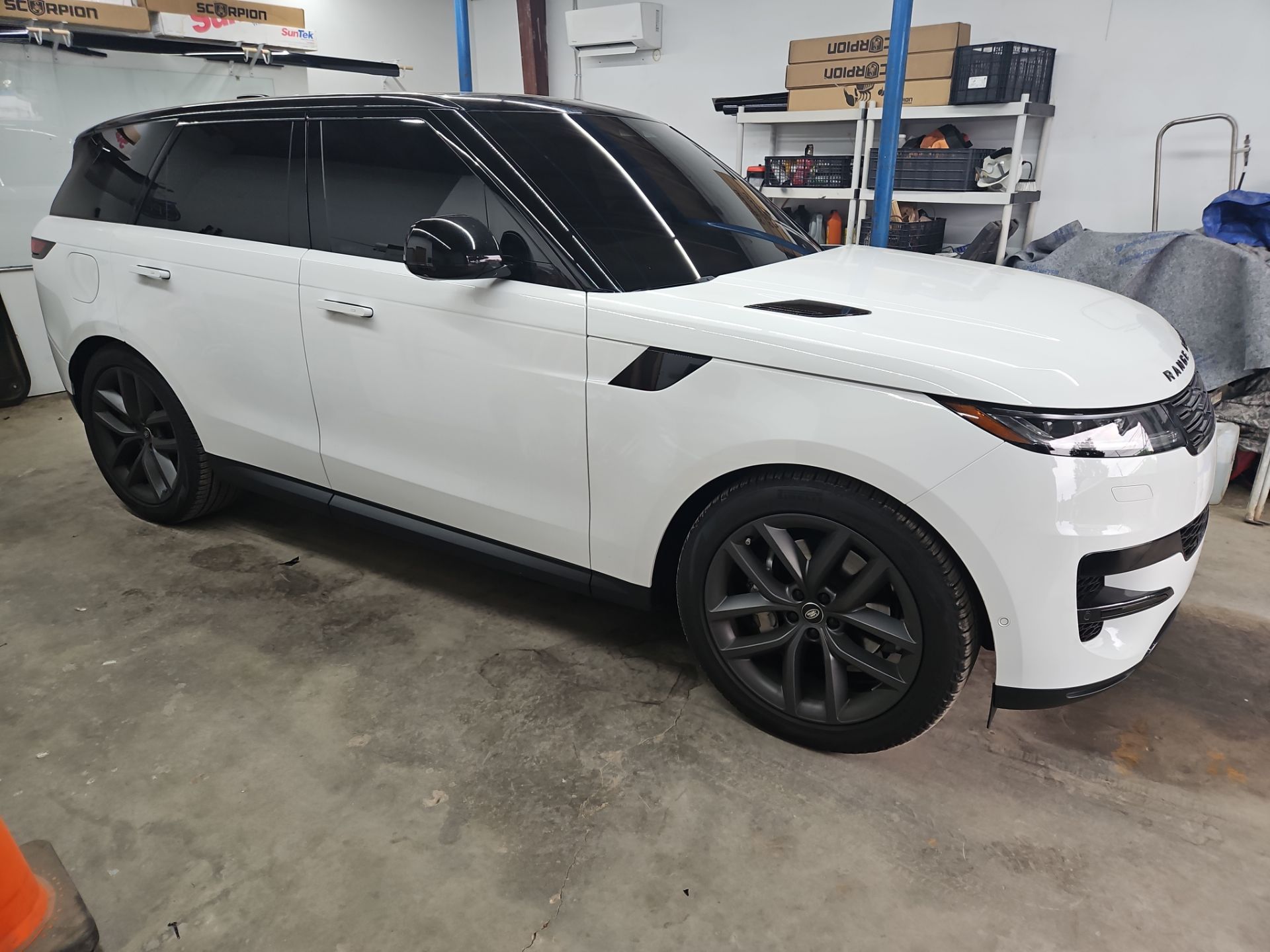 the service being done is window tinting on a white luxury suv the windows have been tinted to a dark shade providing privacy and reducing glare the overall appearance is sleek and modern the car likely benefits from heat reduction and UV protection due to the tint being applied