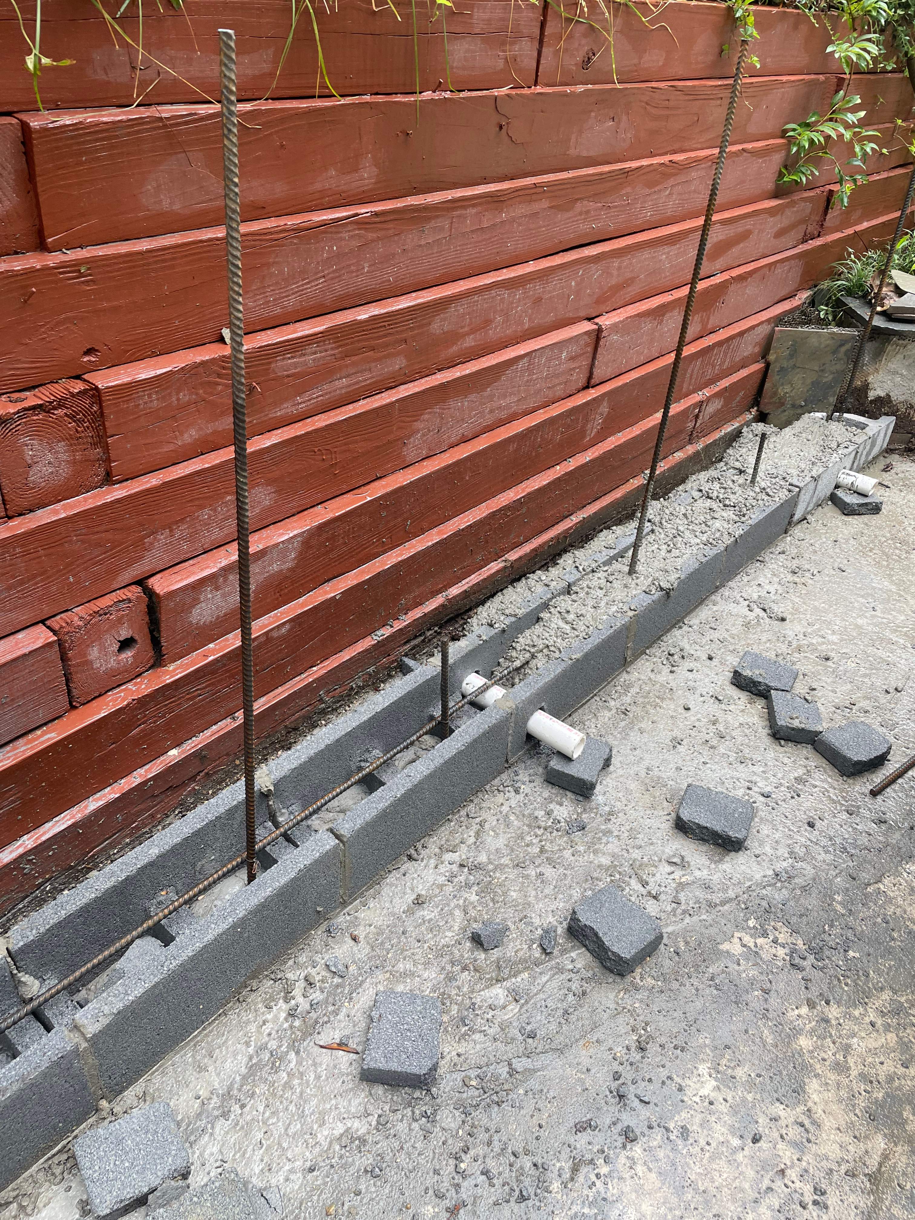 Pool Surround remodel with retaining walls, new waterfall and water slide by Fairfax Contractors, LLC