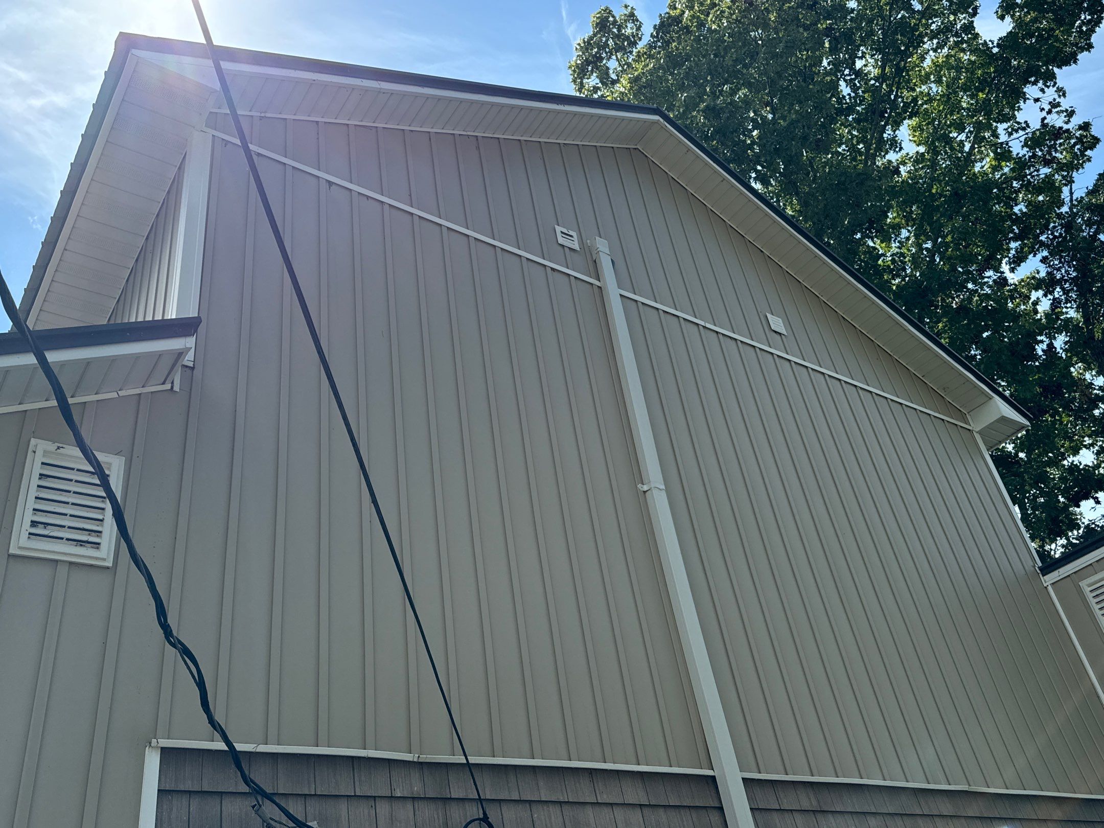 the service being done is cleaning the exterior vertical siding of a house using pressure washing techniques