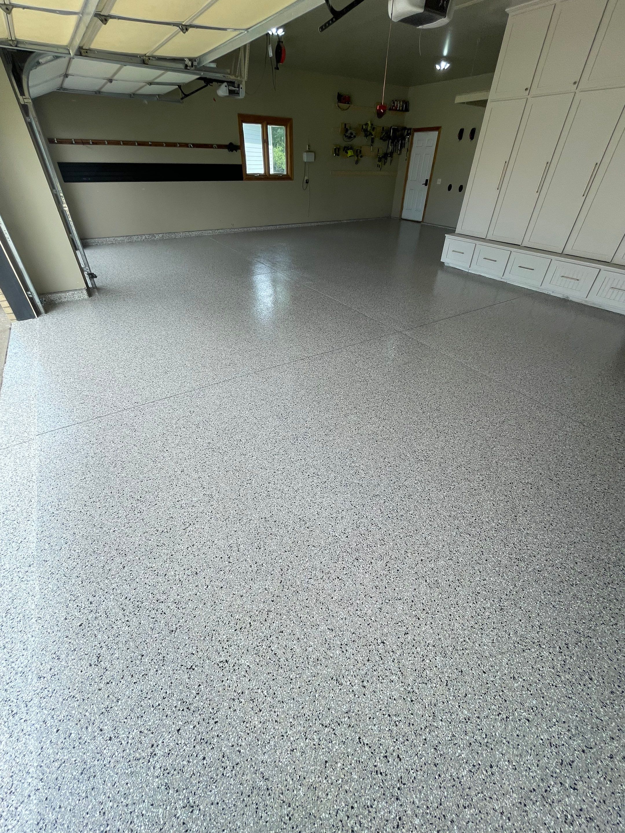 Cabin FEver Flake Garage Floor Coating Installation in Sioux Falls by Select Painting, Coatings & Garage Cabinets