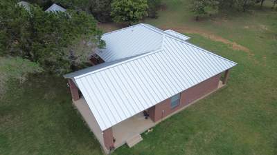 Aerial view of completed metal roof on brick home