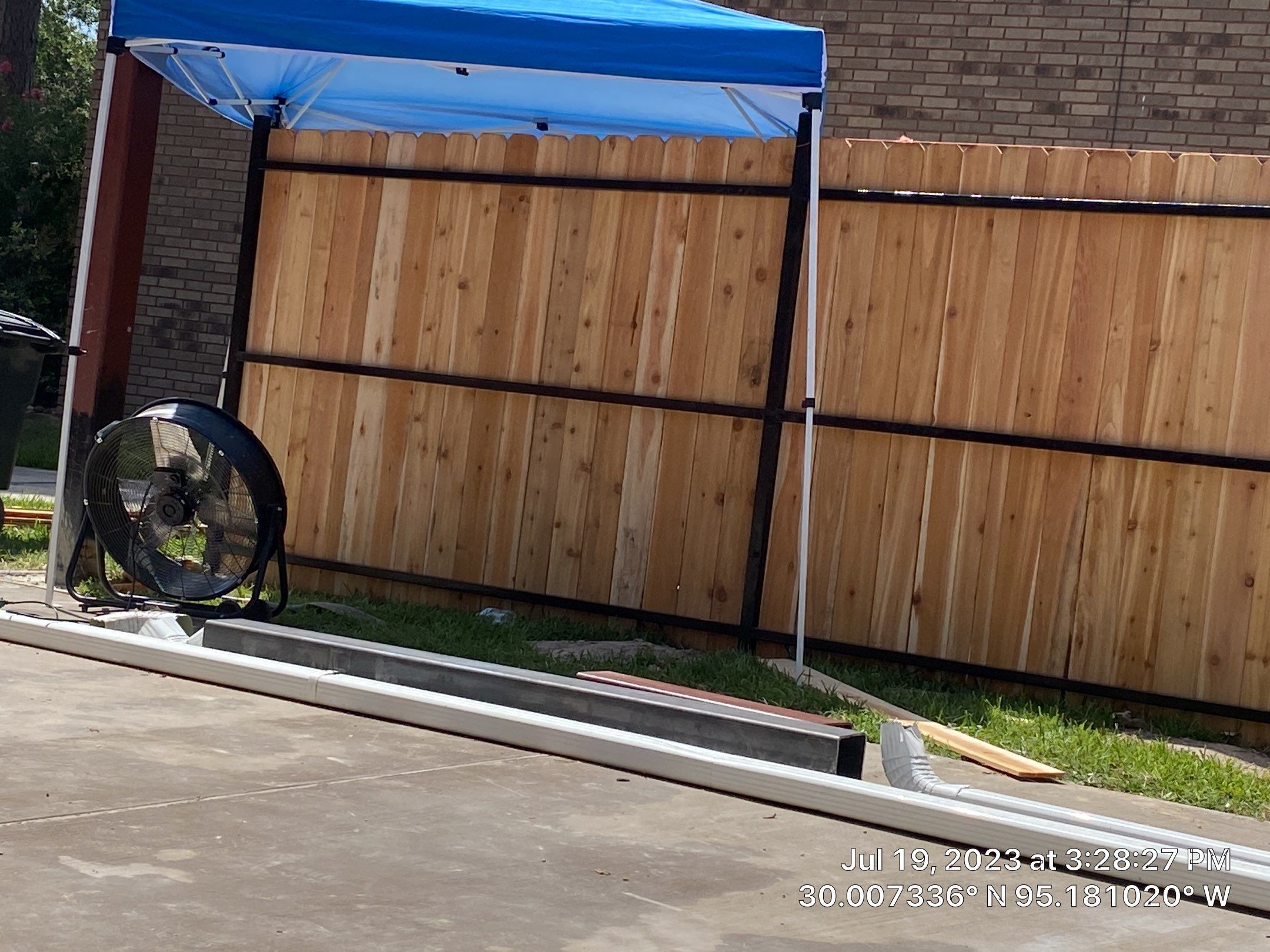 Complete metal driveway gate install with solar powered opener. Metal fence frame with Cedar Pickets by Astro Outdoor Designs 