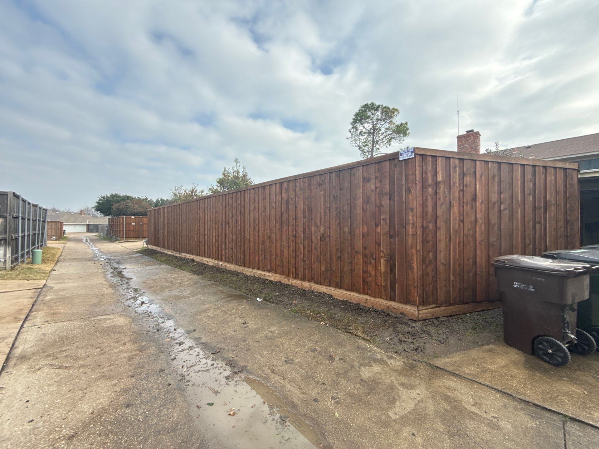 Pre-Stained board on board w/ trim and kickboard using 1x4 cedar trim by Grizzly Fence And Patio