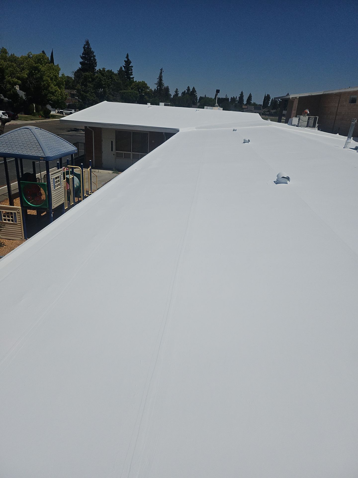 Single-ply restoration system using Benchmark/PUMA XL coatings over TPO single-ply roofing by Straight Edge Roofing Inc
