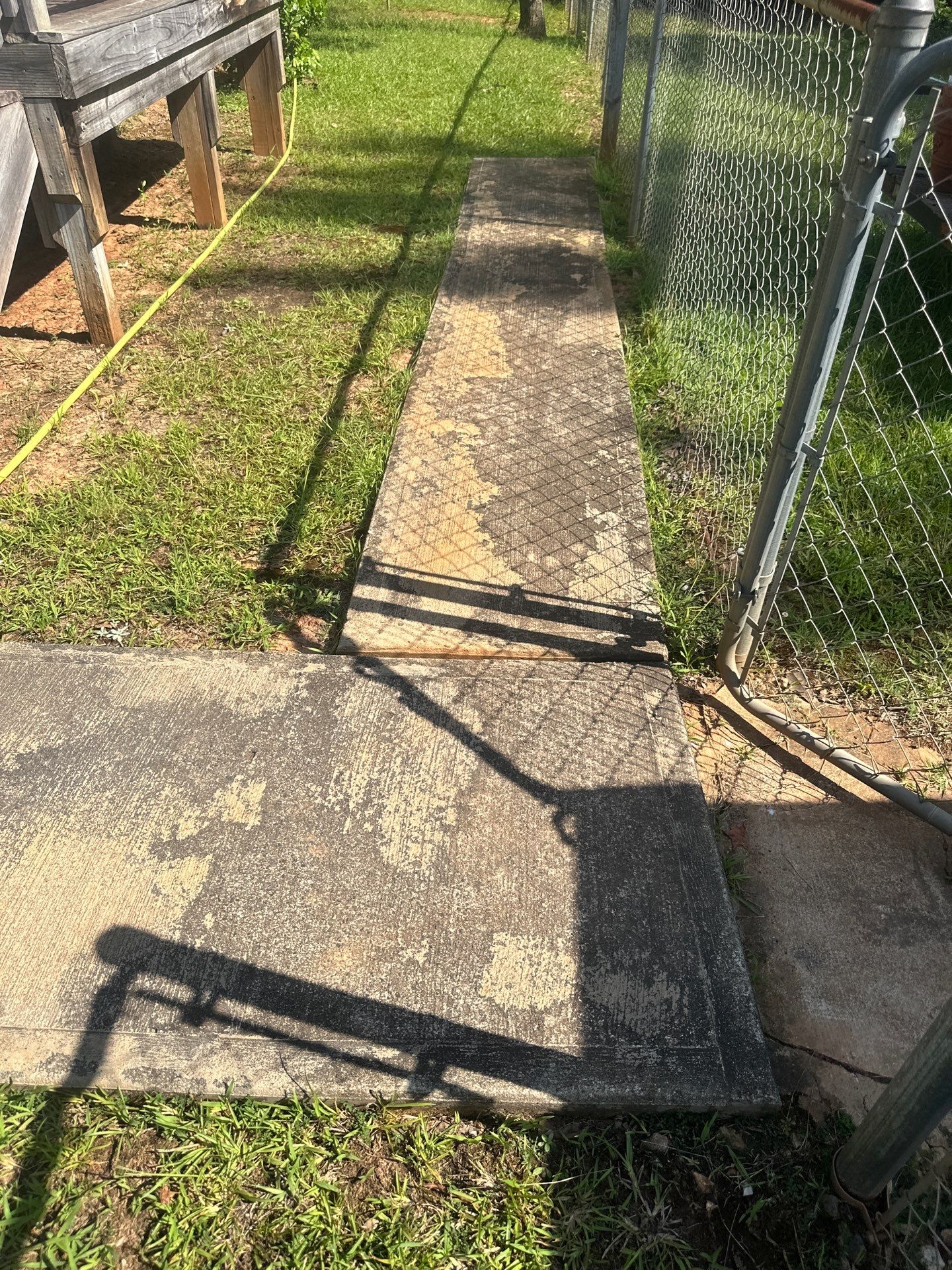 cleaning and restoring the appearance of a concrete walkway using pressure washing techniques