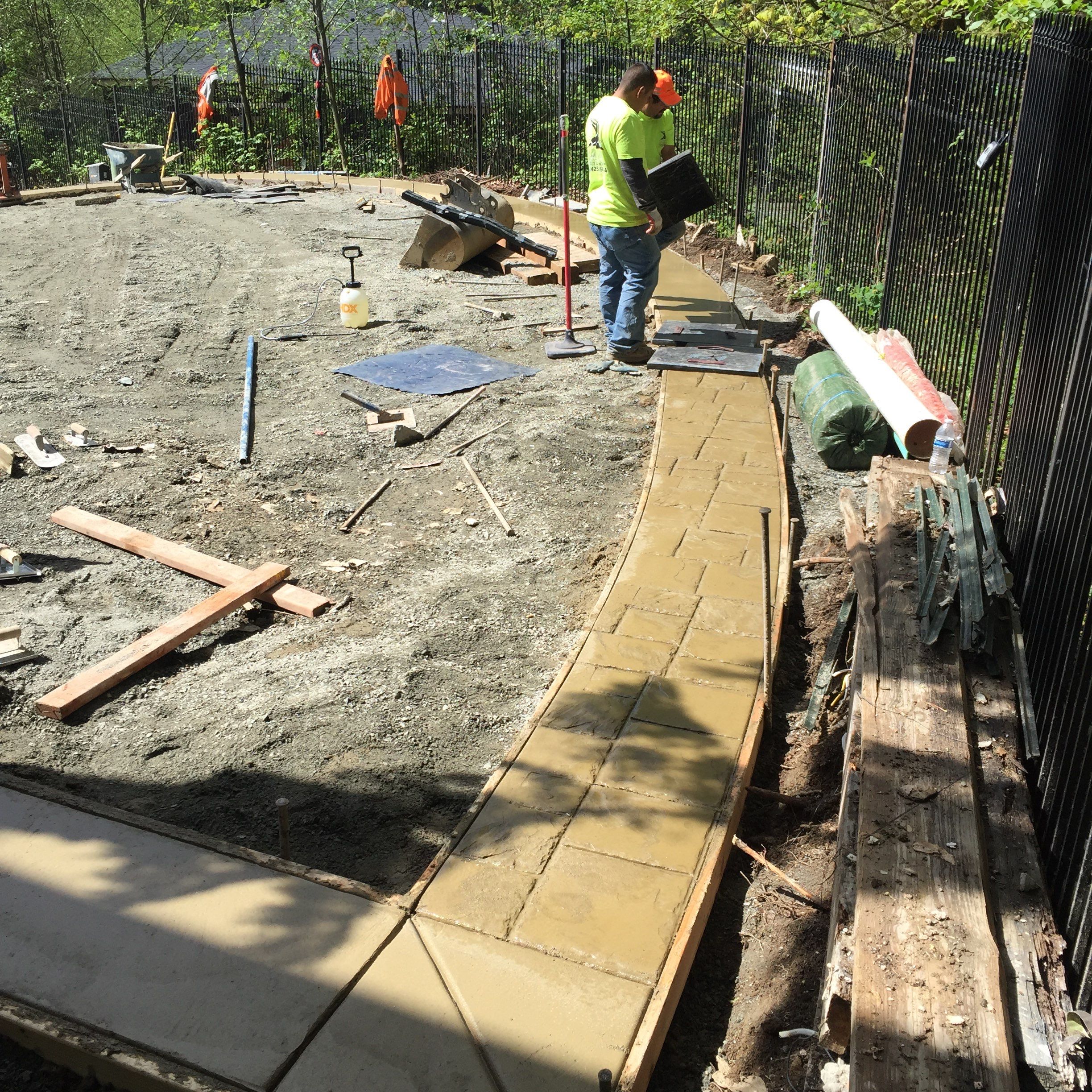 Asphalt Driveway and Stamped Concrete Patio Finish  by Jireh Asphalt & Concrete Inc 