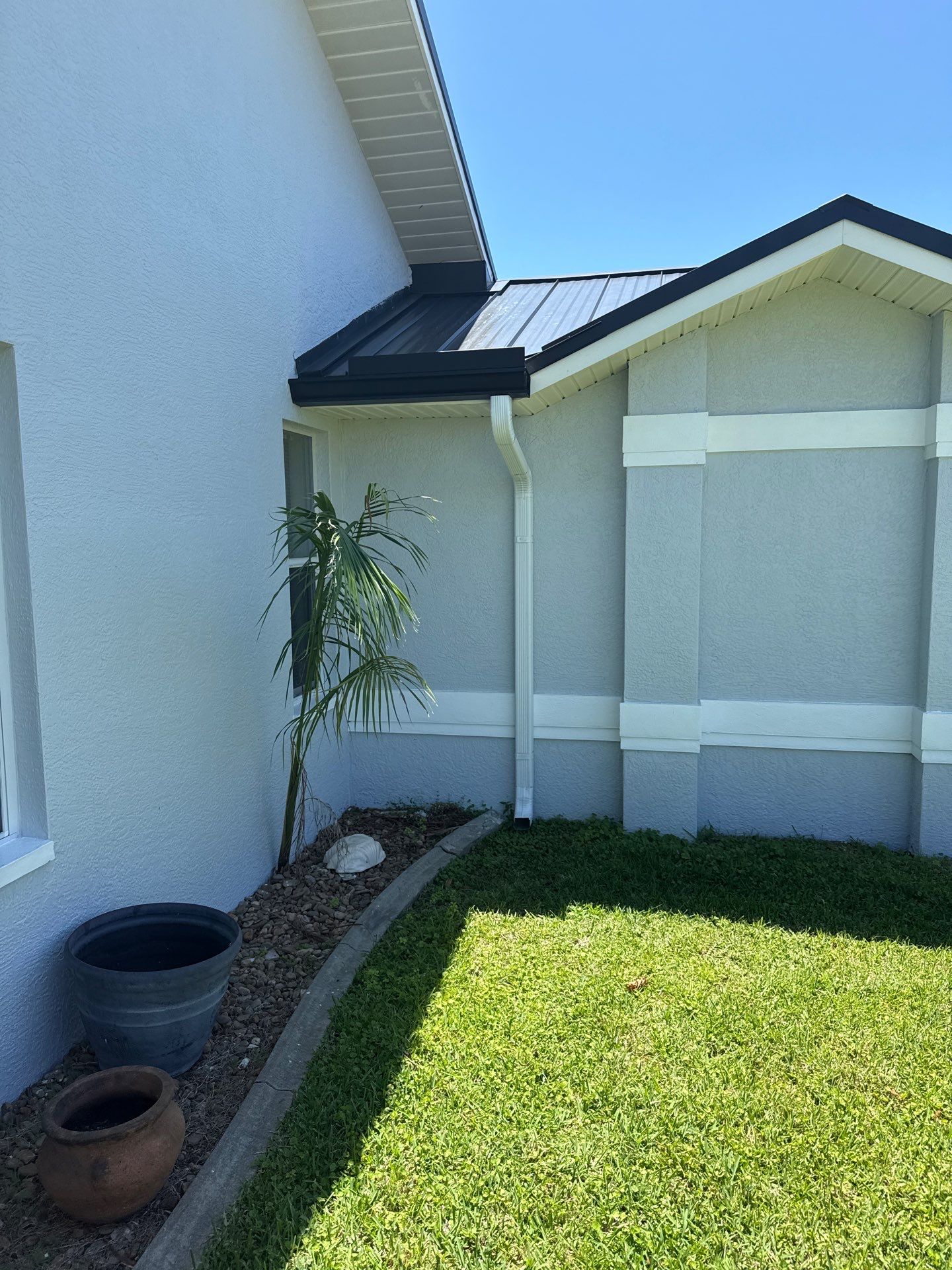 Black Seamless Gutters and White Downspouts in Cape Coral FL by Gutter Professors