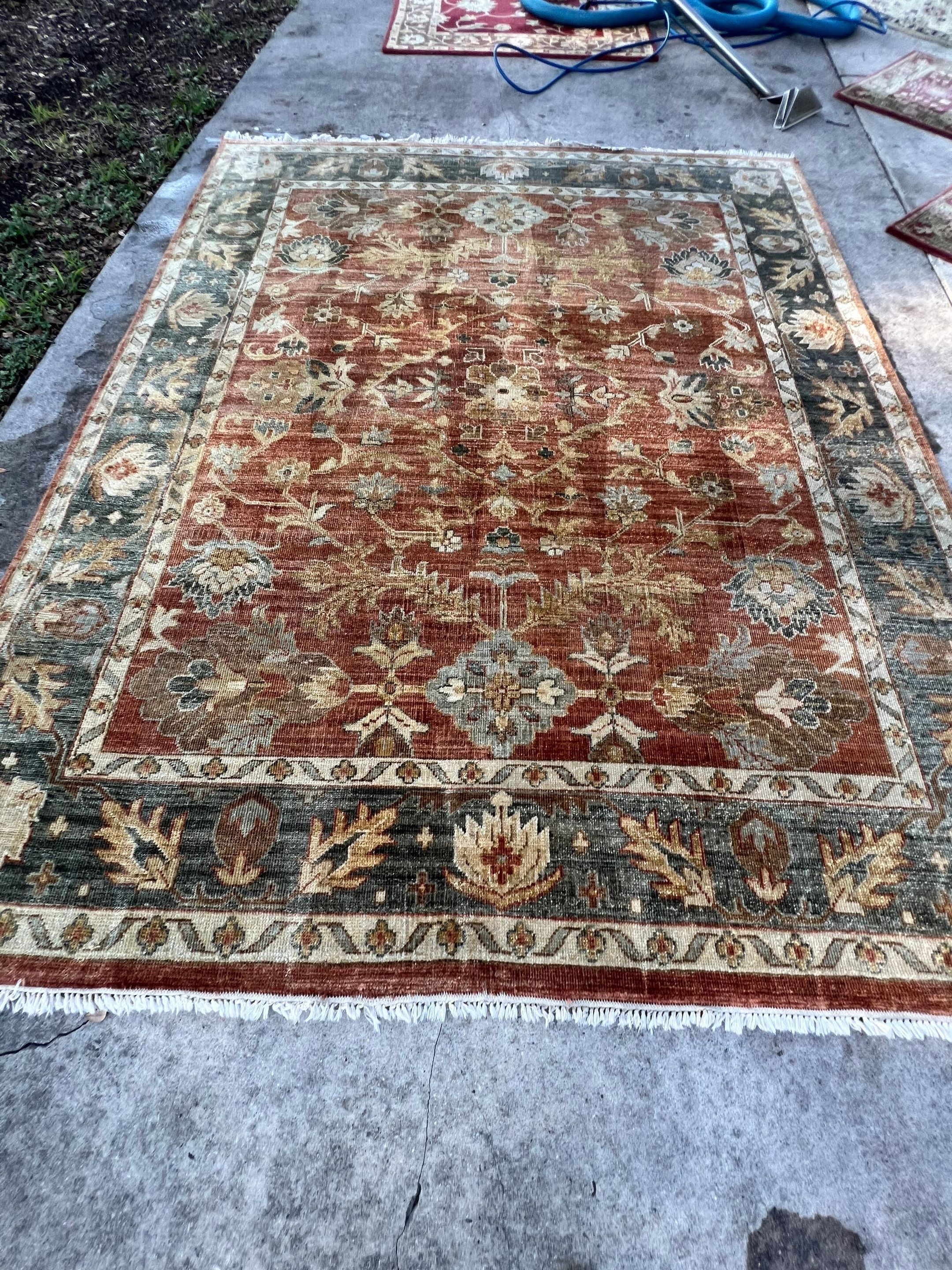 the photo shows a fine area rug being cleaned with professional equipment to restore its appearance and remove dirt