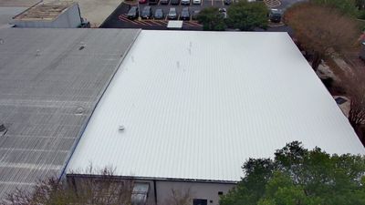 Aerial view of white flat roof next to grey roof