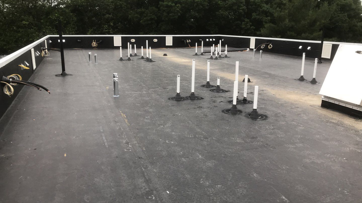 Commercial Roofing Installation using EPDM with white gutters by A Plus Exterior