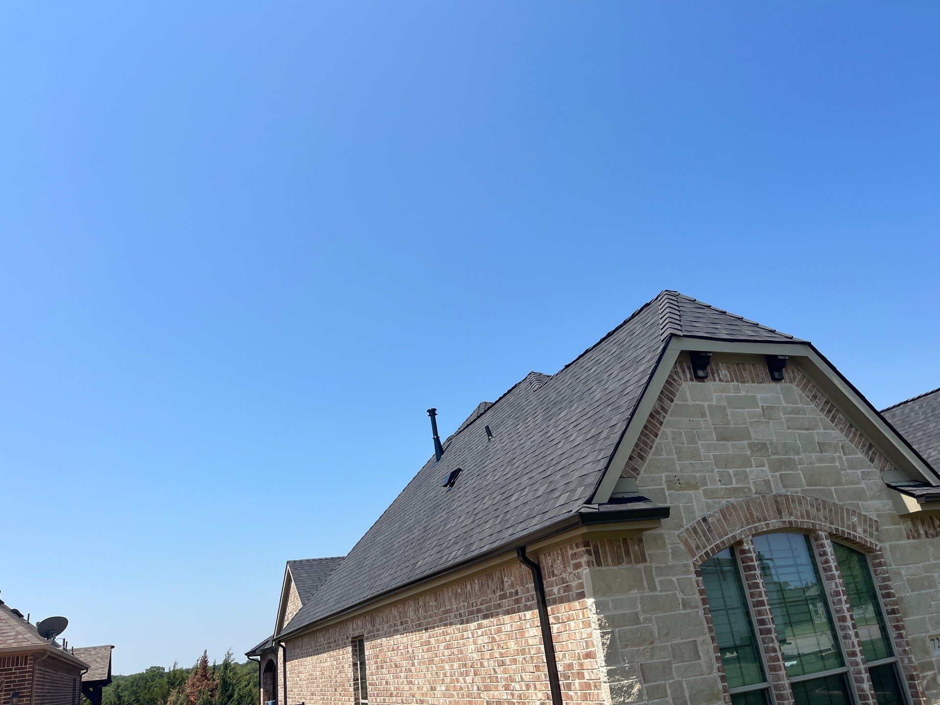 IKO Granite Black-Light Brown with dark brown sections brick house  by Tejas Roofworks + Restoration