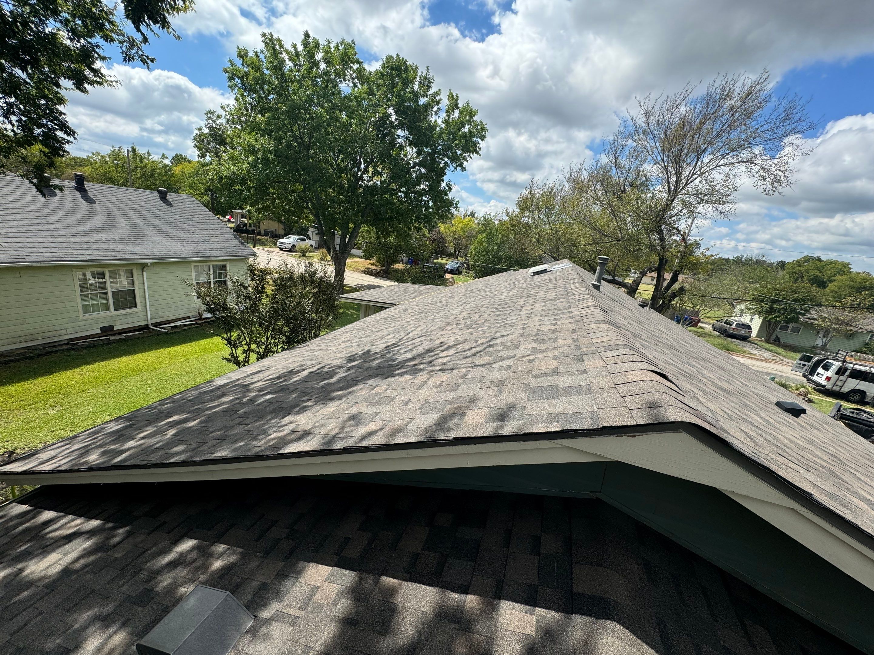 IKO Driftshake-Dark green siding house by Tejas Roofworks + Restoration