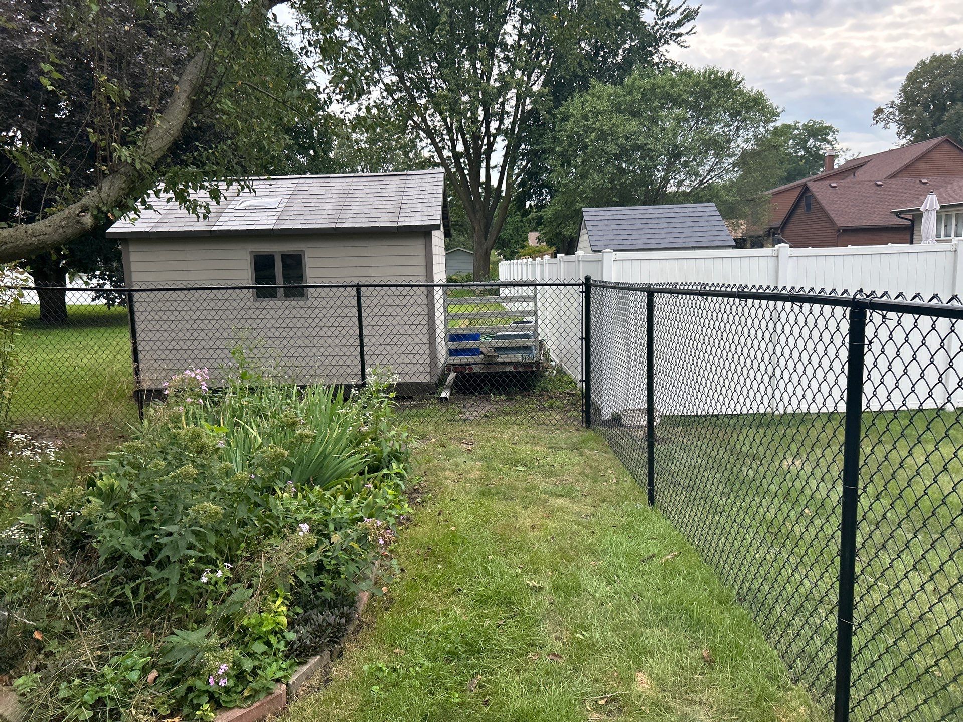 Black Vinyl-Coated Chain Link Fence Installation in Waterloo by Perfect Picket Fence and Stain