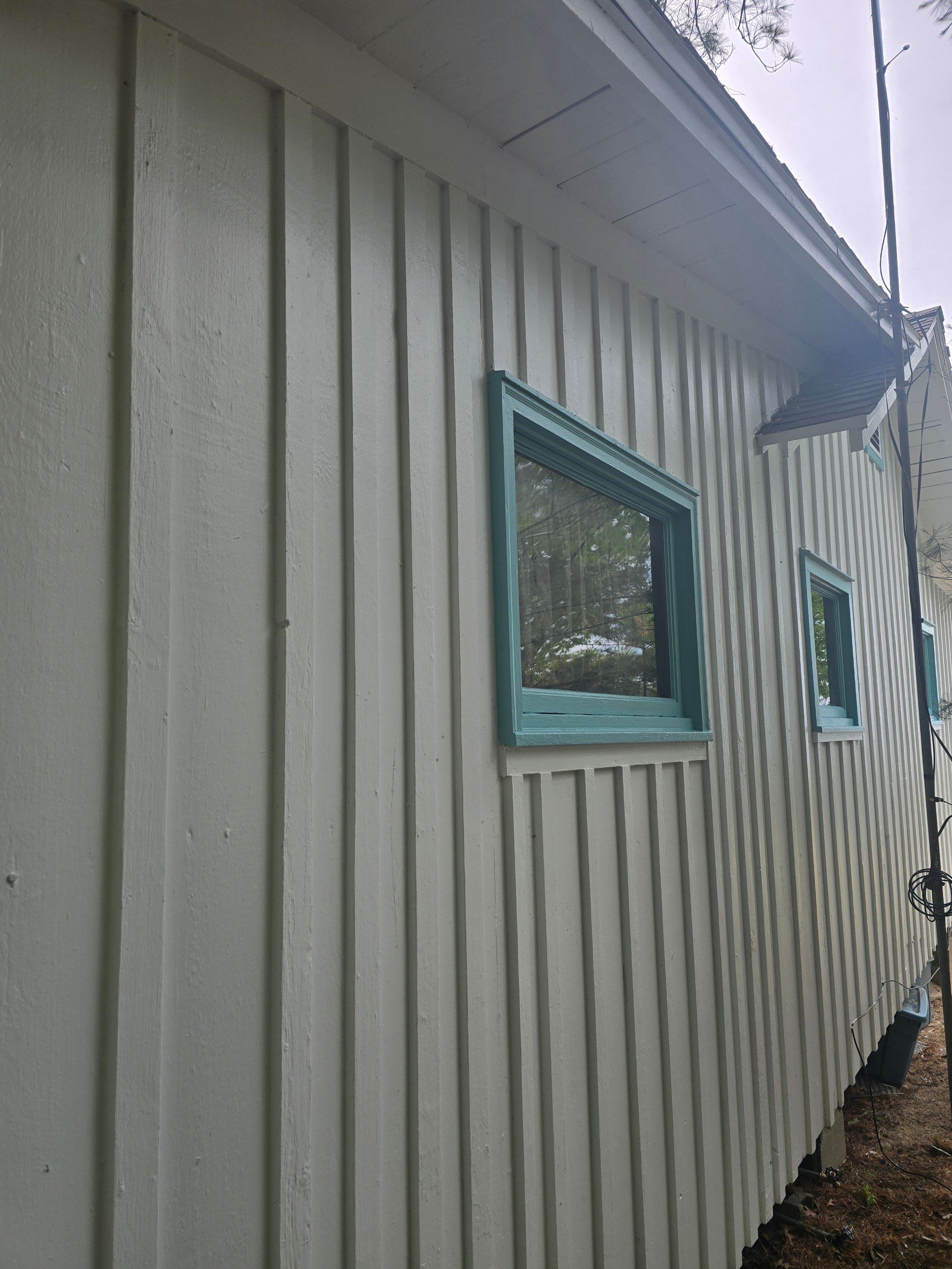 Lakeside Cottage Exterior Painting and Teal Trim Restoration in Mears by Gordon Painting
