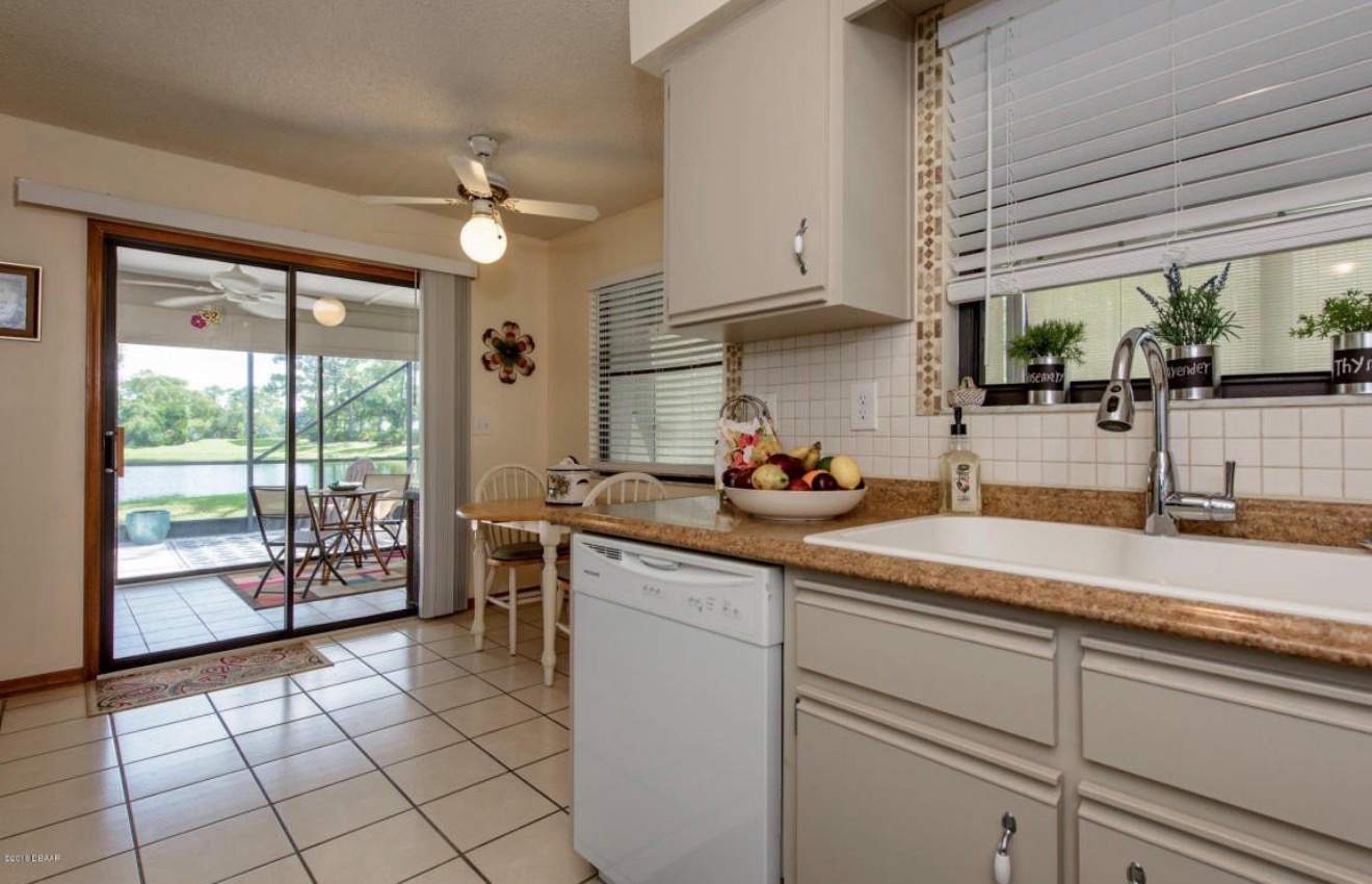 Modern Kitchen Remodel in Port Orange Featuring Waterfall Quartz Island by Acies Renovations