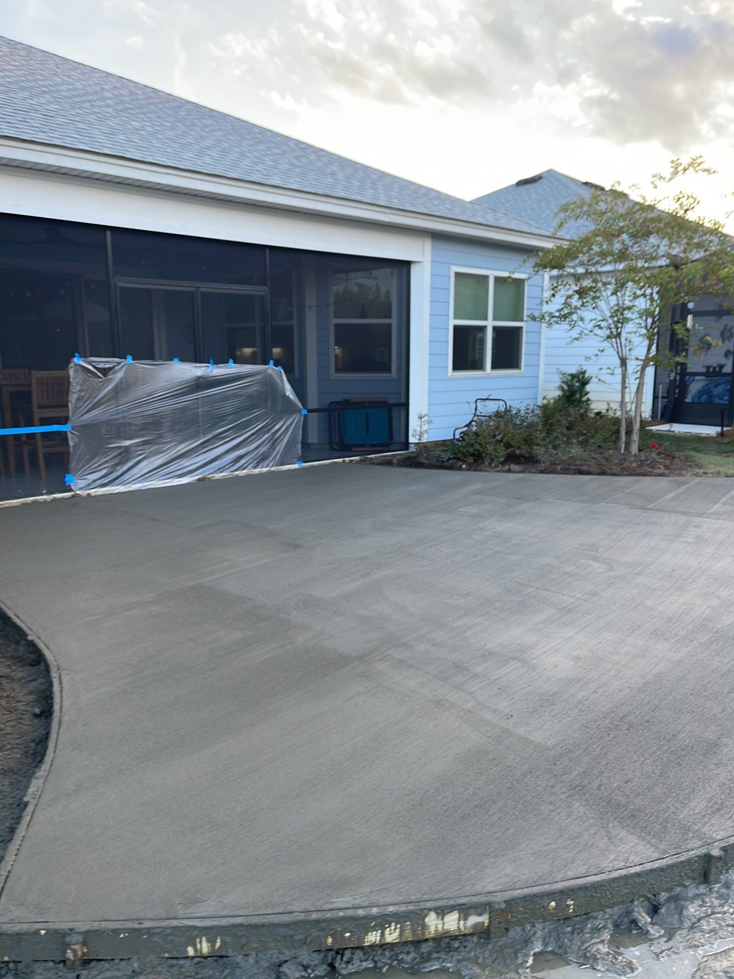 Custom Curved Concrete Patio and Paver Border in Hardeeville by Lowcountry Scapes, LLC