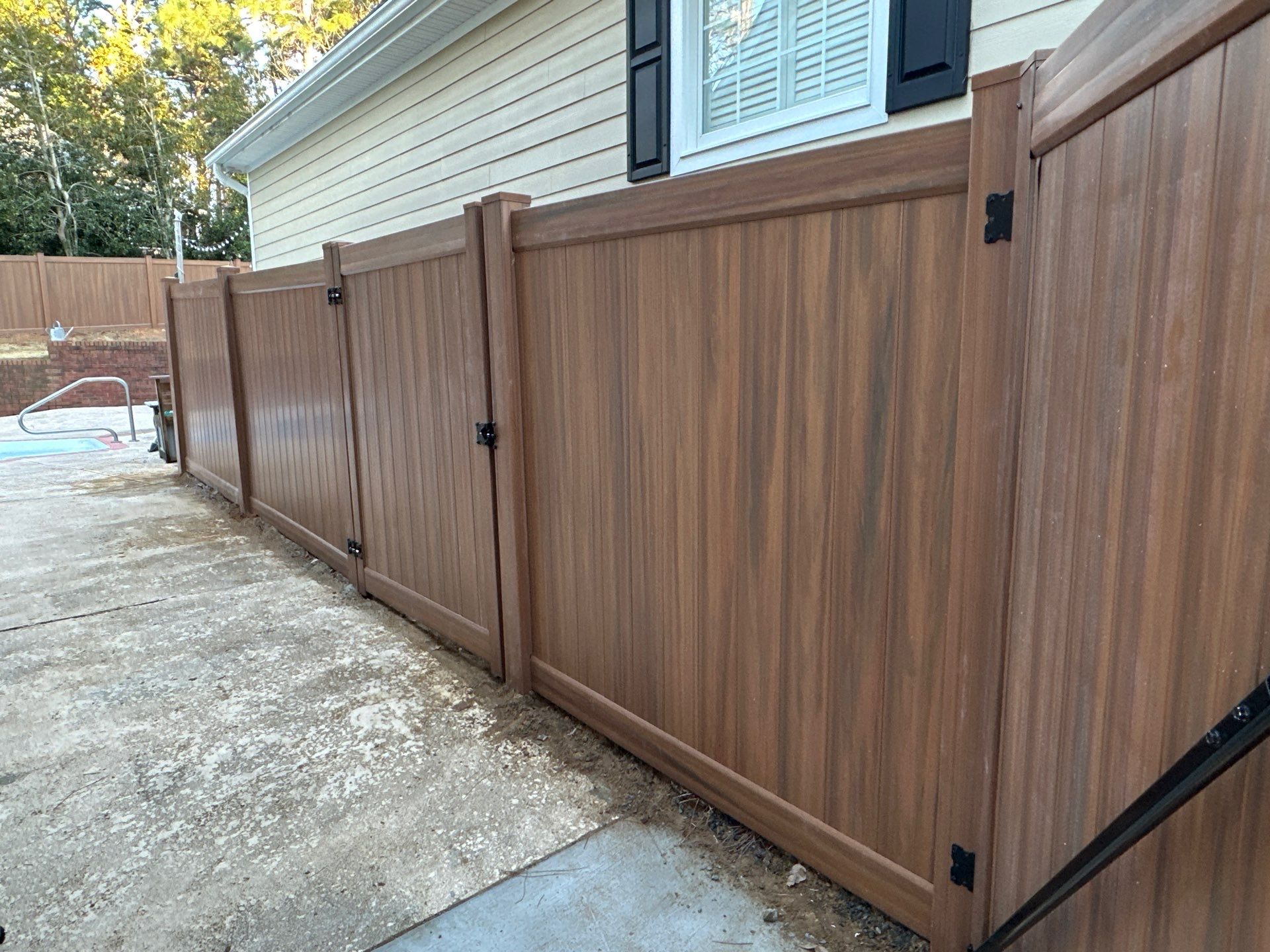 Mocha Walnut Wood-Grain Vinyl Privacy Fence Installation in Southern Pines by Superior Fence and Rail