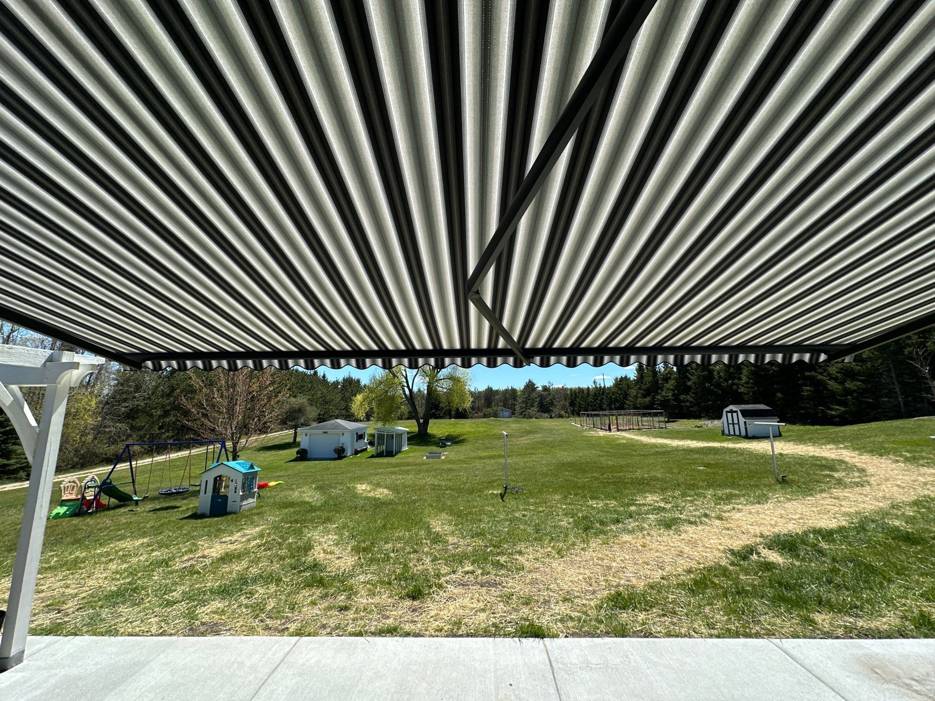 Sunesta Retractable Awning Installation for Concrete Patio in Gaylord by Rainbow Seamless Systems