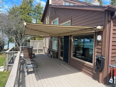 Retractable Striped Awning Installation for Waterfront Composite Deck in Charlevoix