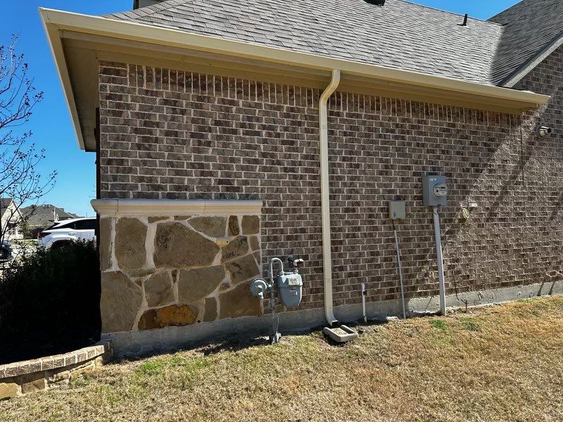 Brown brick/mixed stone with Malarkey Natural Wood by Tejas Roofworks + Restoration