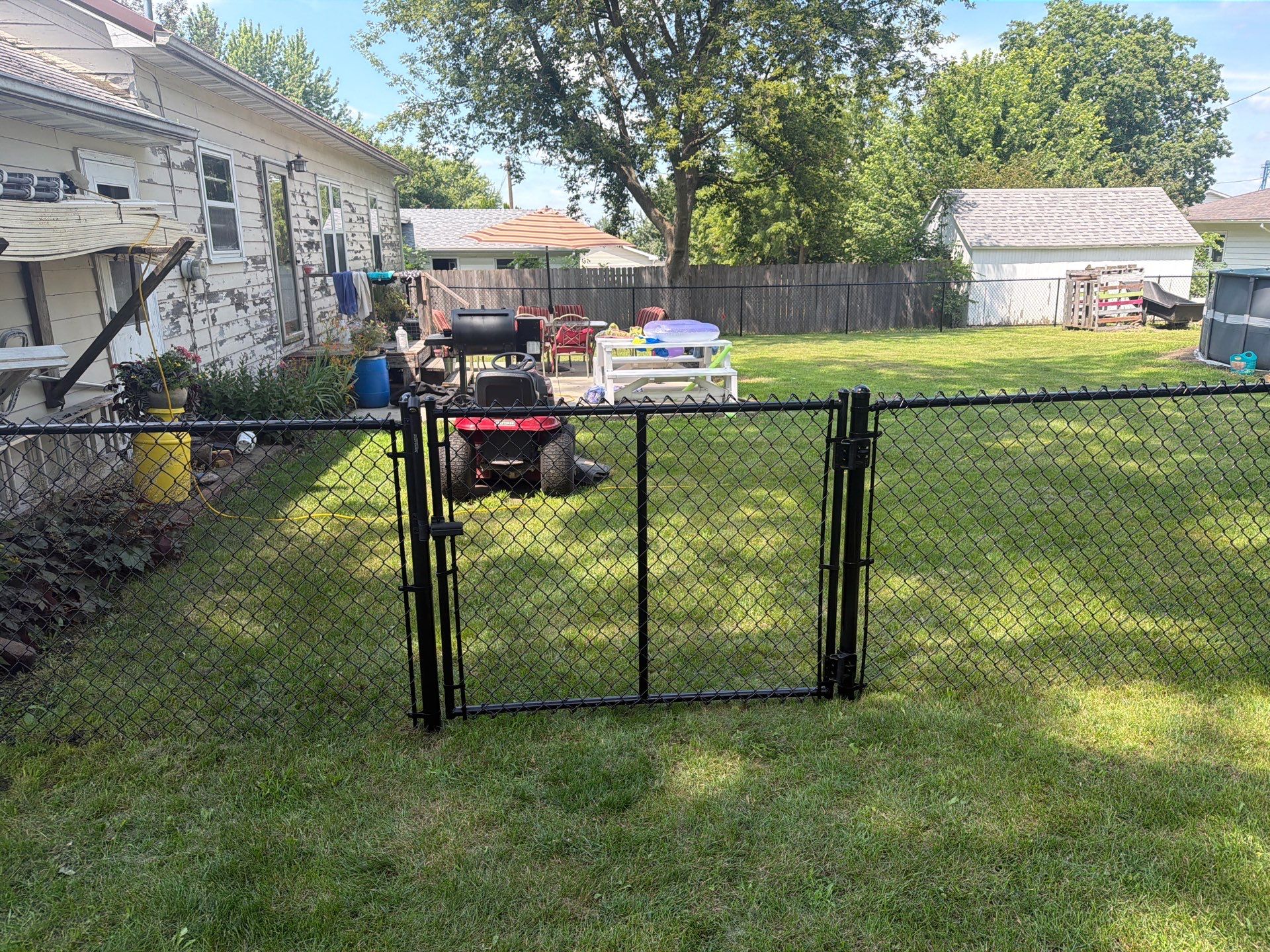 Black Chain Link Backyard Fence Installation in Tripoli, IA by Perfect Picket Fence and Stain
