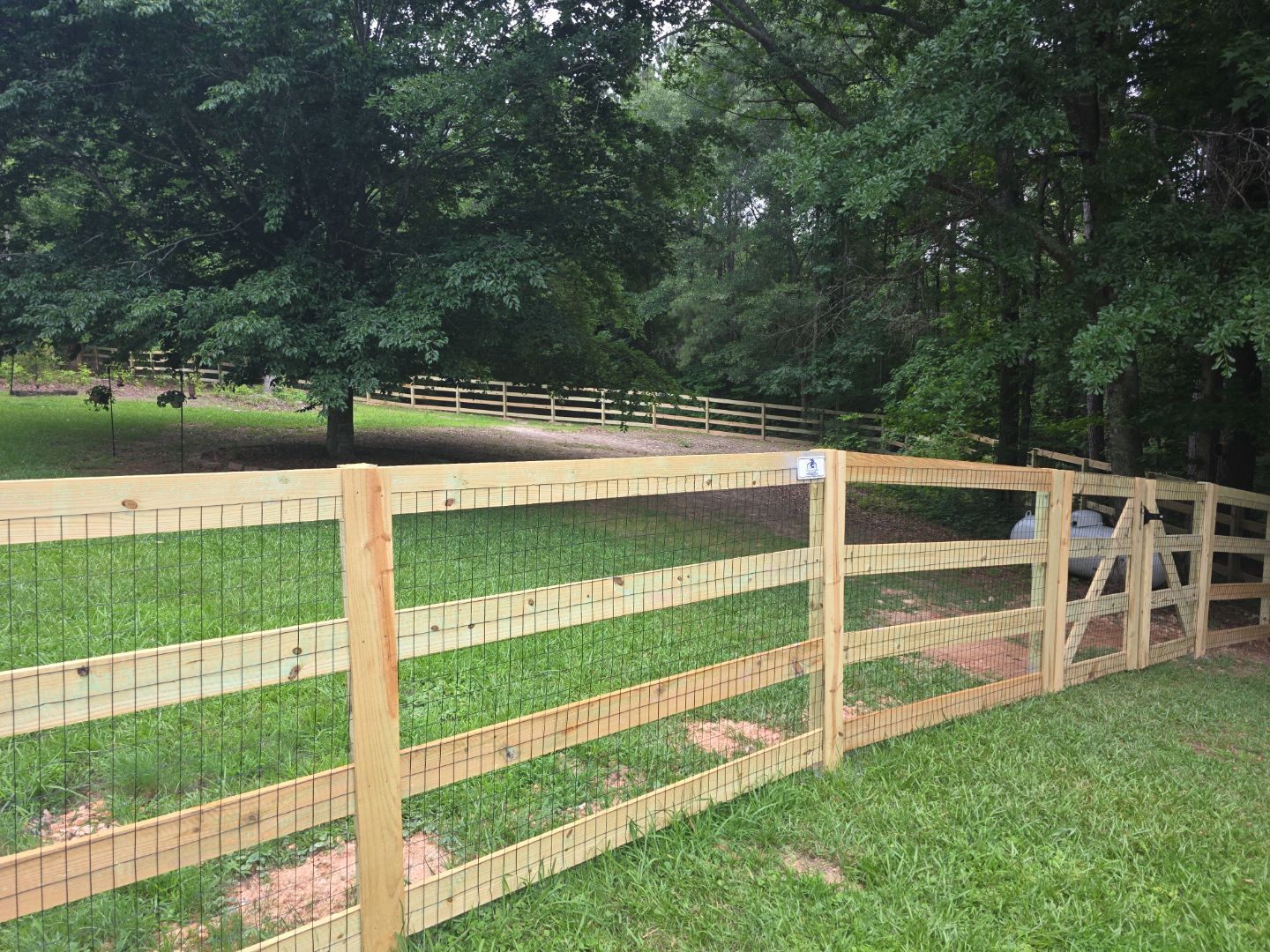 Fence Installation of a 4 Rail Ranch Style Fence with Welded Wire by Titans of Timber Fence & Stain
