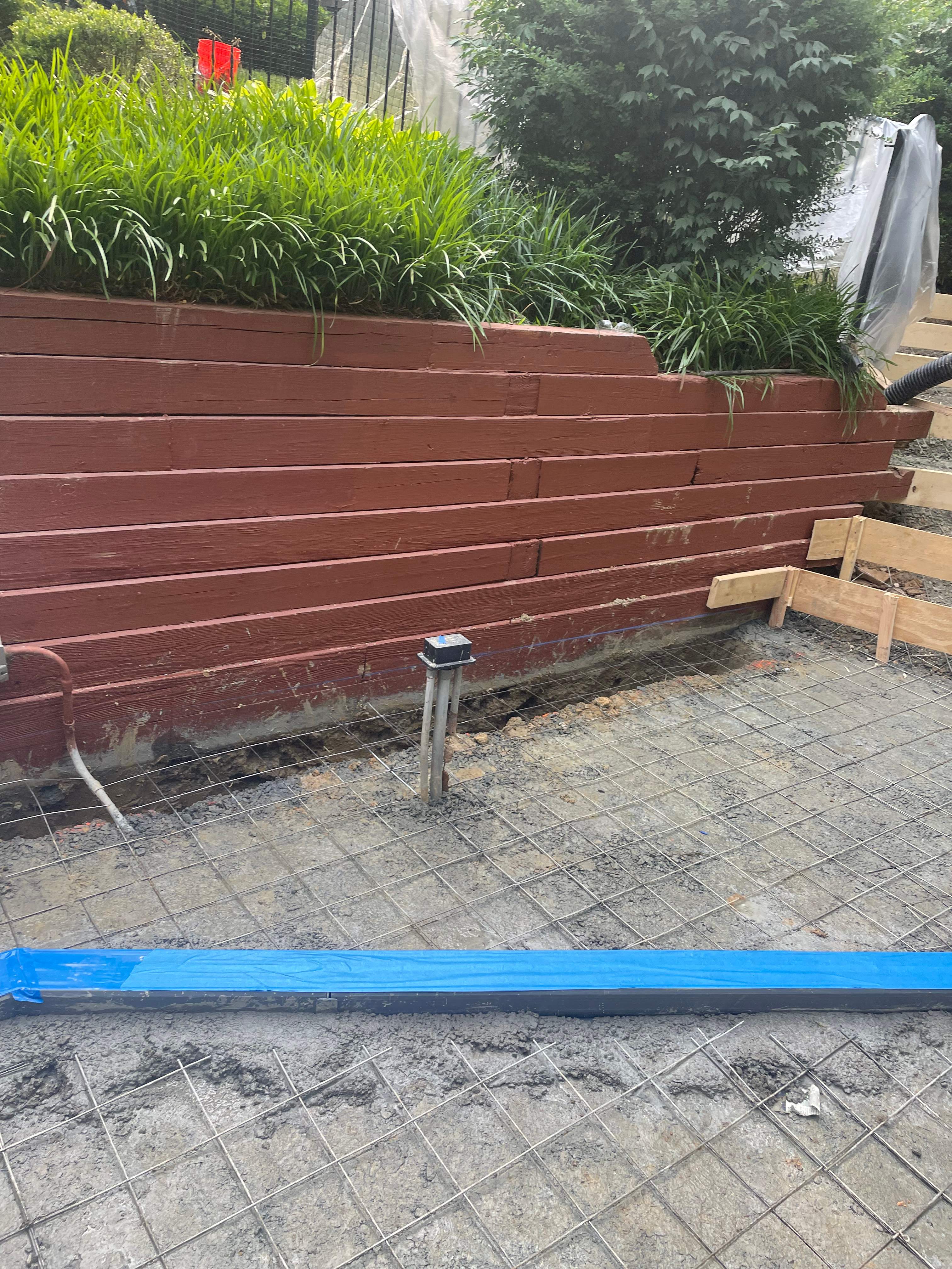 Pool Surround remodel with retaining walls, new waterfall and water slide by Fairfax Contractors, LLC