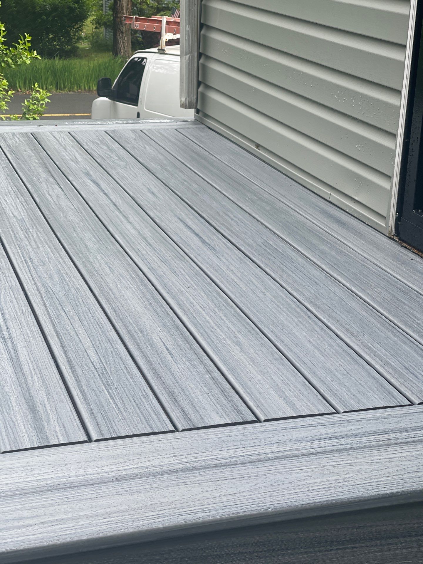 Raised Gray Composite Deck and Staircase Construction in Pocono Summit, PA by Herts Roofing & Construction
