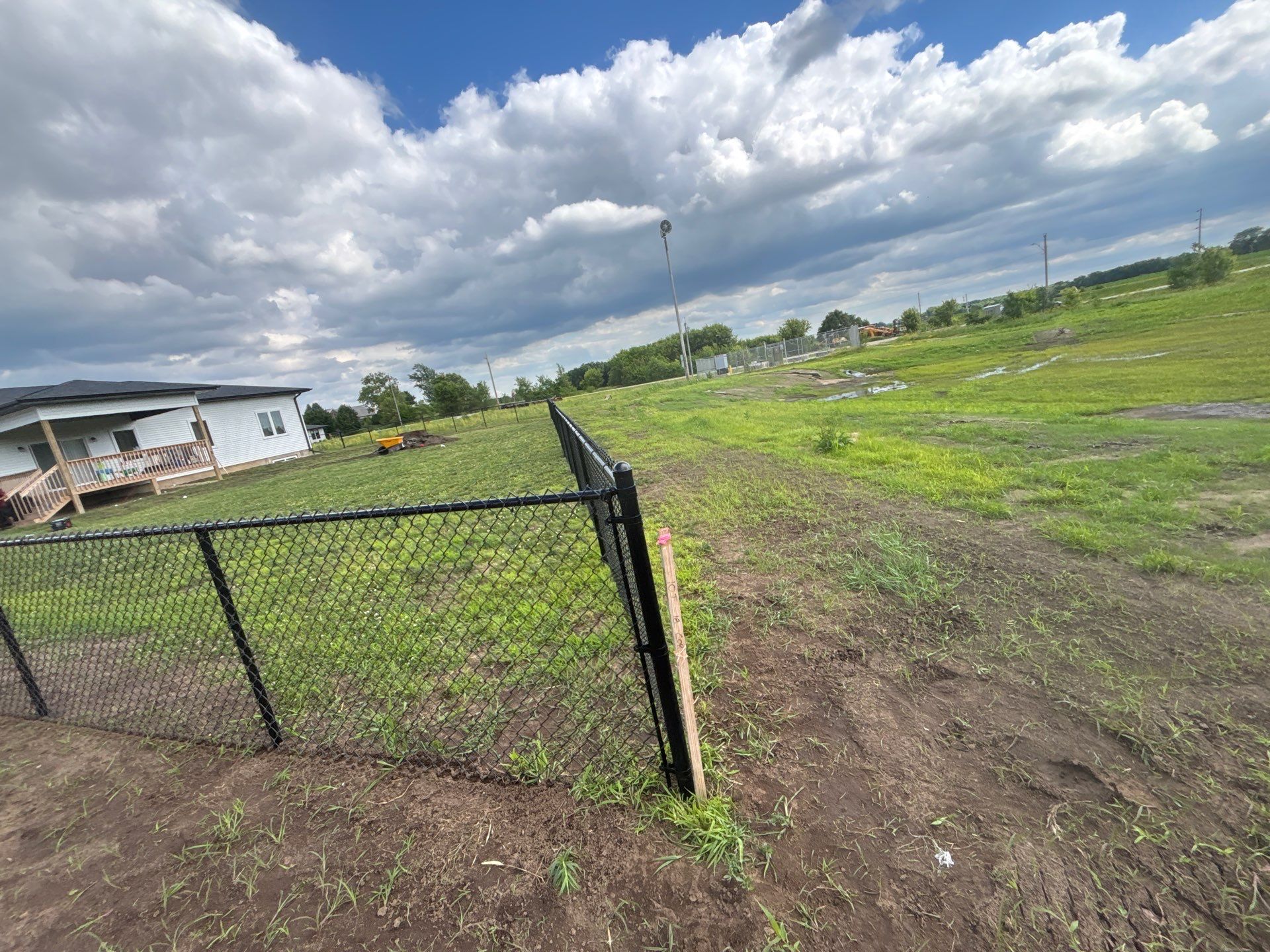 Black Vinyl-Coated Chain Link Fence and Residential Site Grading by Perfect Picket Fence and Stain