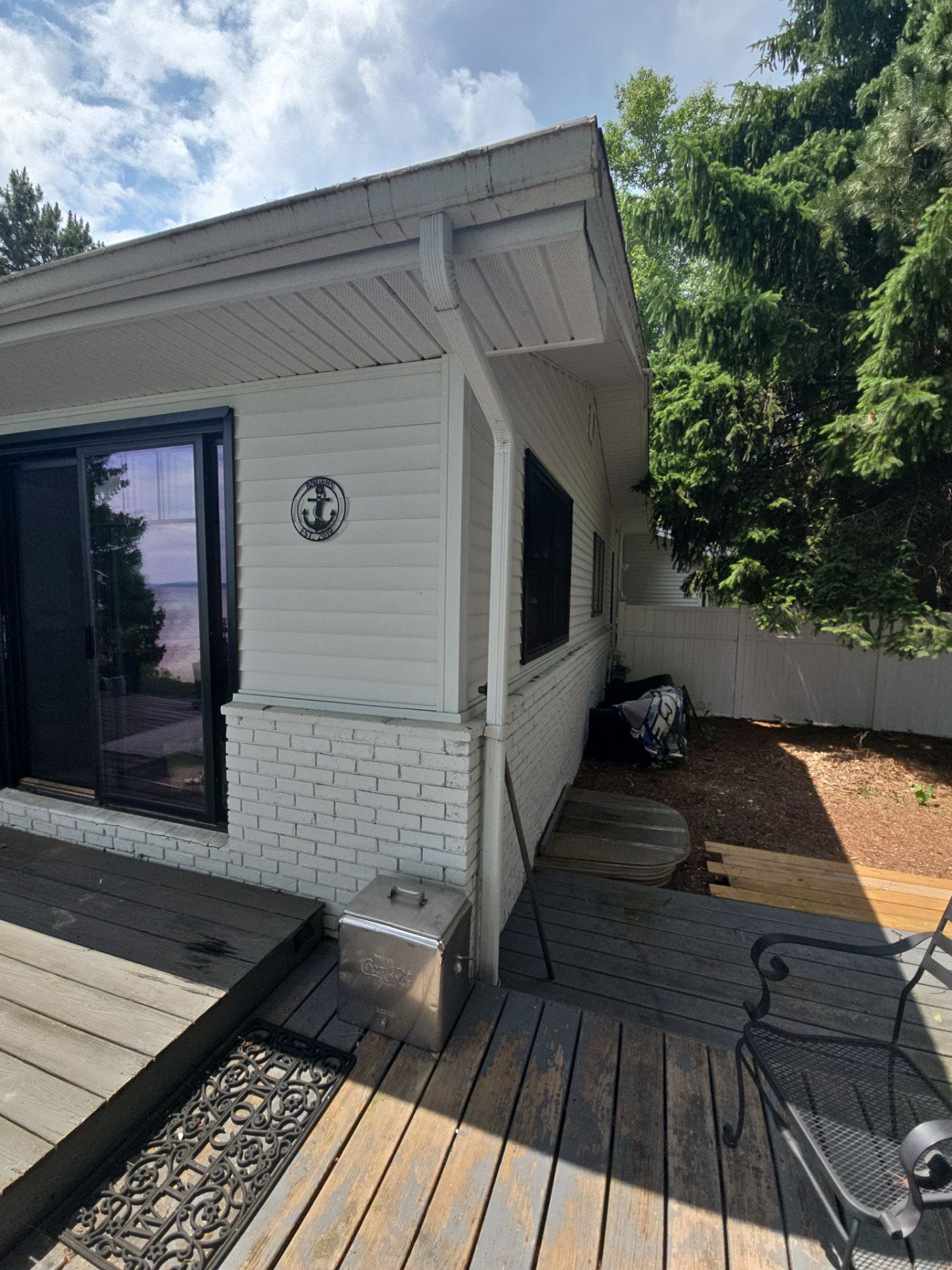 Black Gutter and Gutter Helmet Installation for Suttons Bay Home by Rainbow Seamless Systems