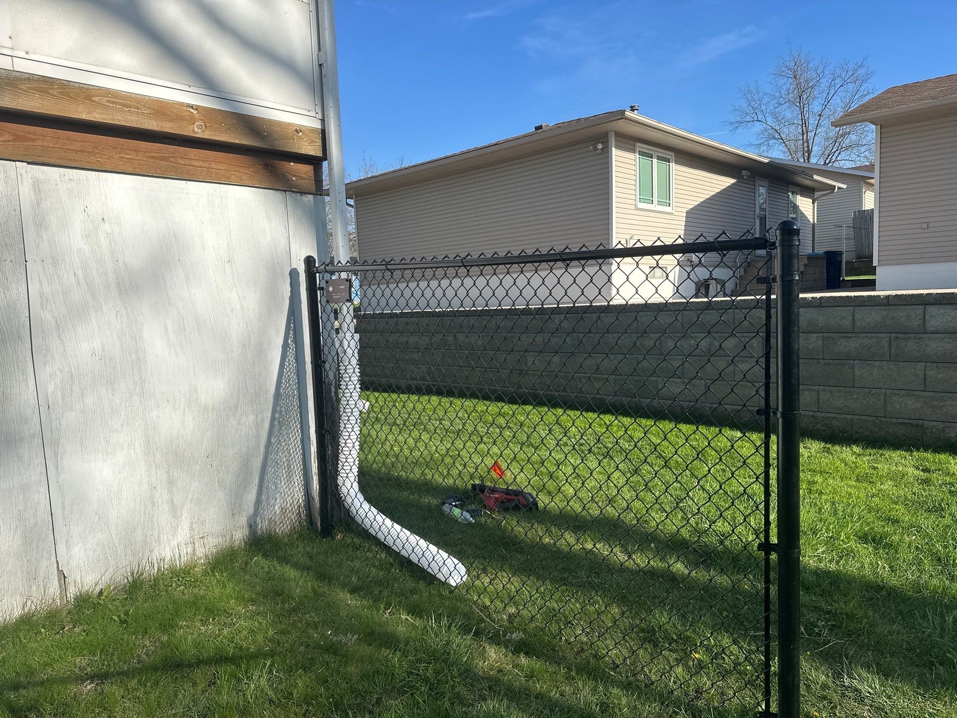 Black Vinyl-Coated Chain Link Fence Installation in Waterloo by Perfect Picket Fence and Stain