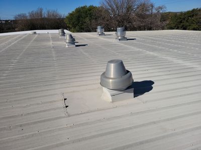 Wide view of metal roof with multiple vent installations