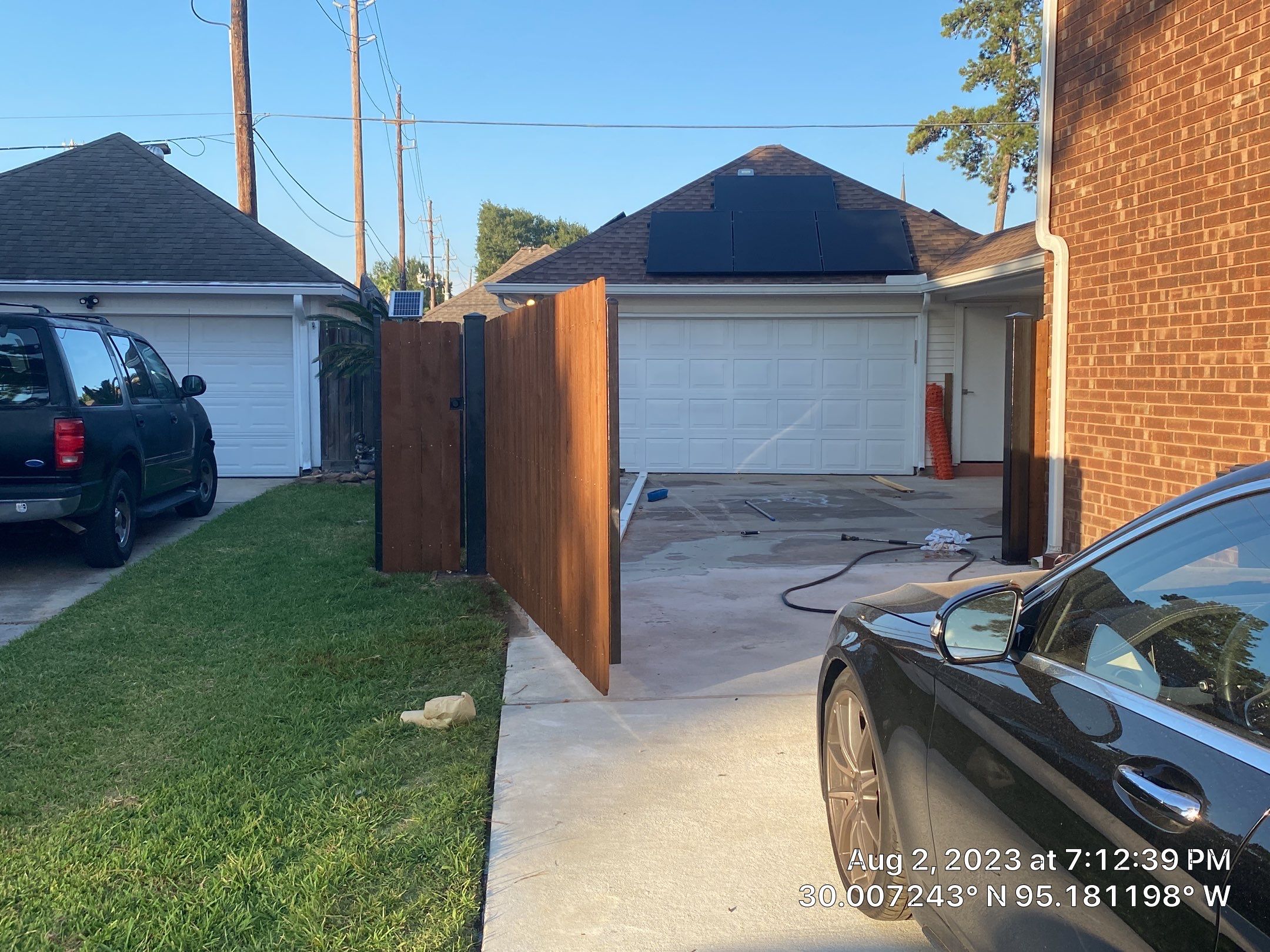 Complete metal driveway gate install with solar powered opener. Metal fence frame with Cedar Pickets by Astro Outdoor Designs 