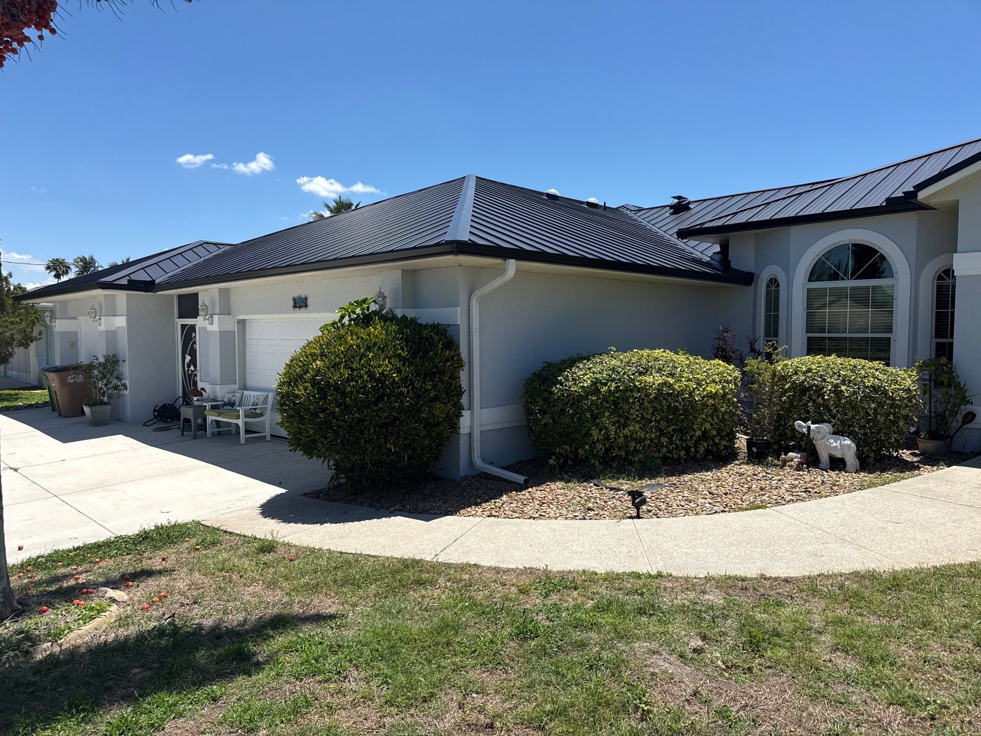 Black Seamless Gutters and White Downspouts in Cape Coral FL by Gutter Professors