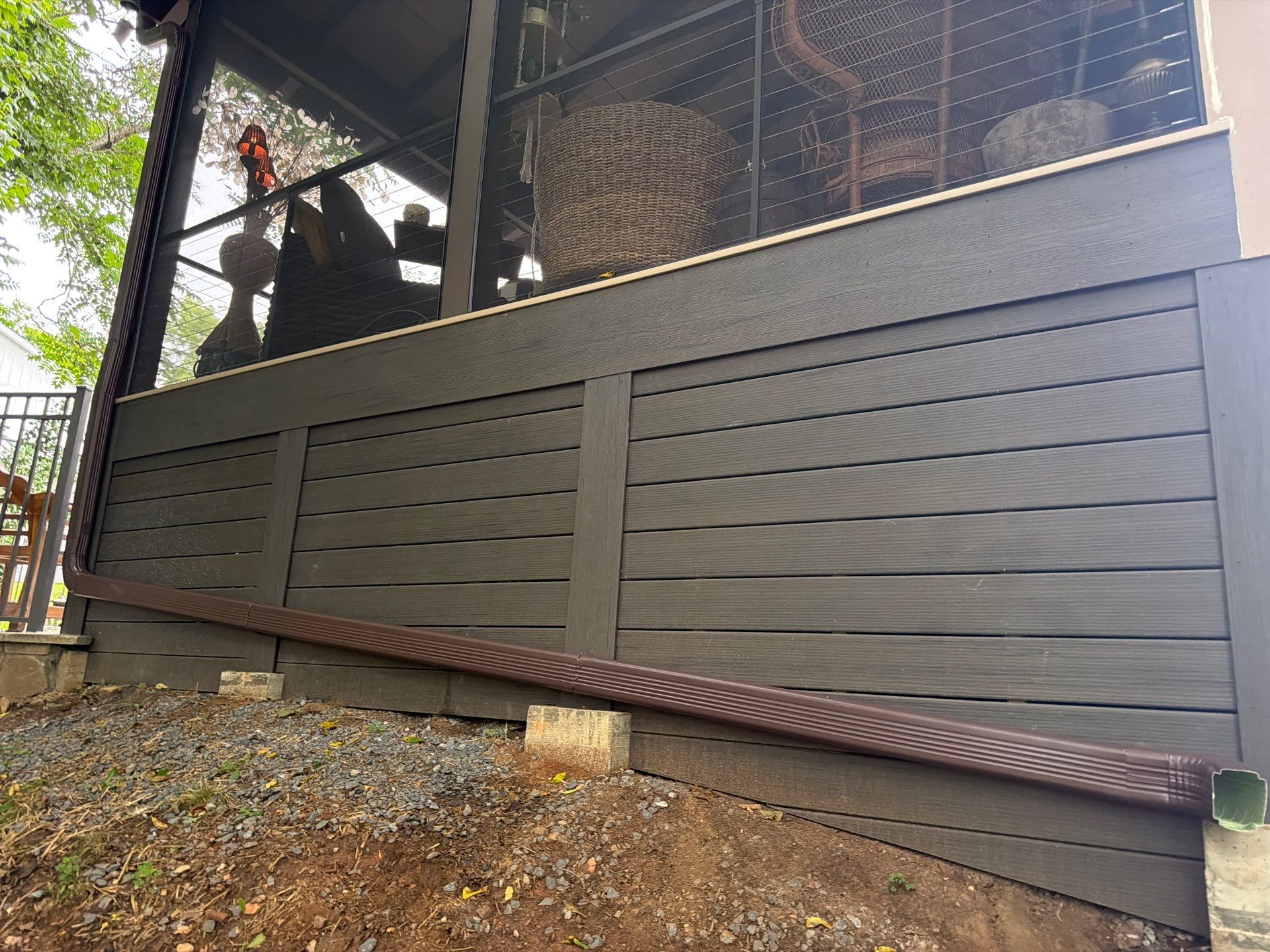 Custom Composite Deck with Stone Fireplace and Modern Cable Railing by Walnut Hollow Decks & Outdoor Living