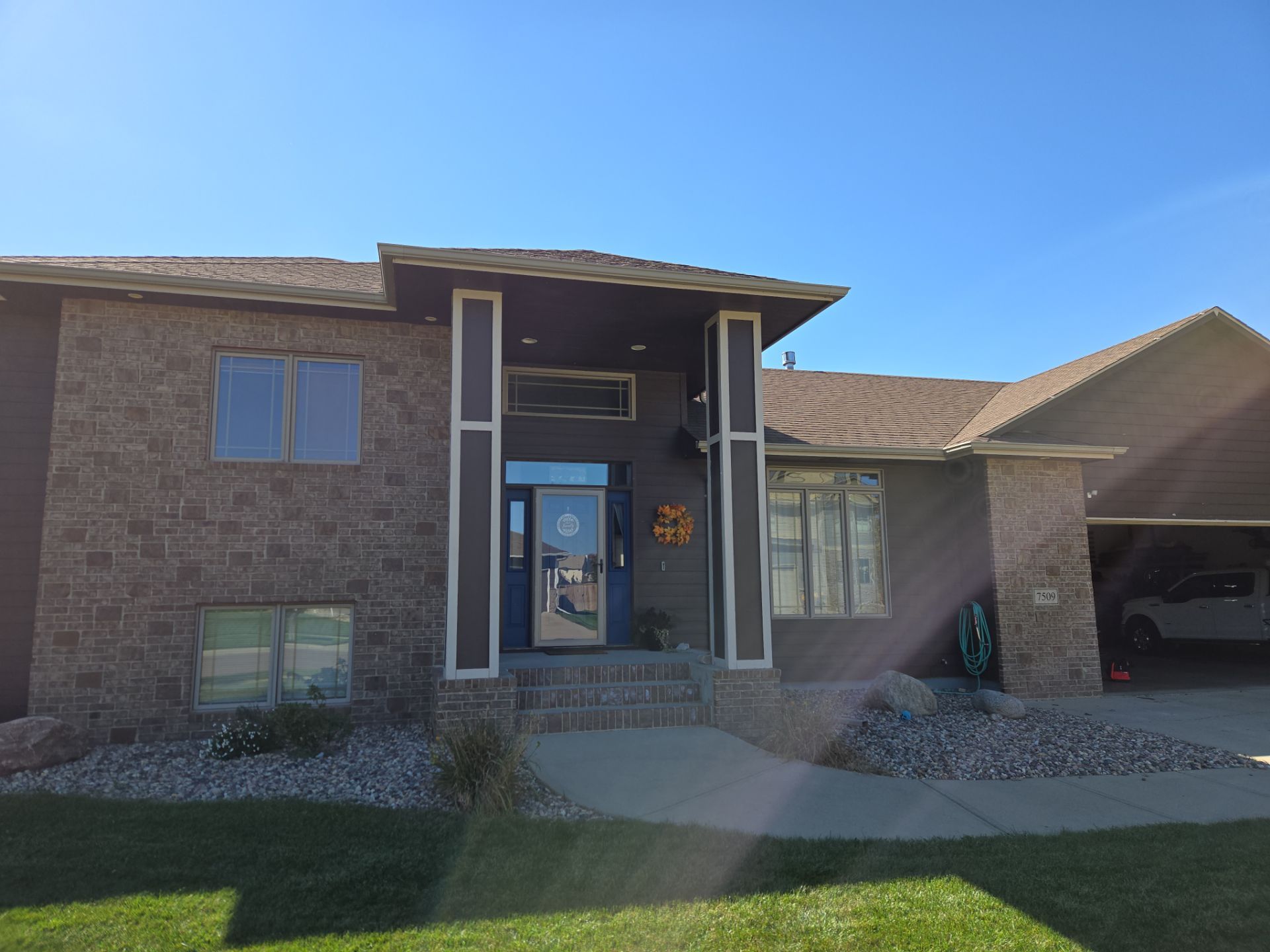 Dark Blue Exterior Home Painting and Siding Refresh in Sioux Falls by Select Painting, Coatings & Garage Cabinets