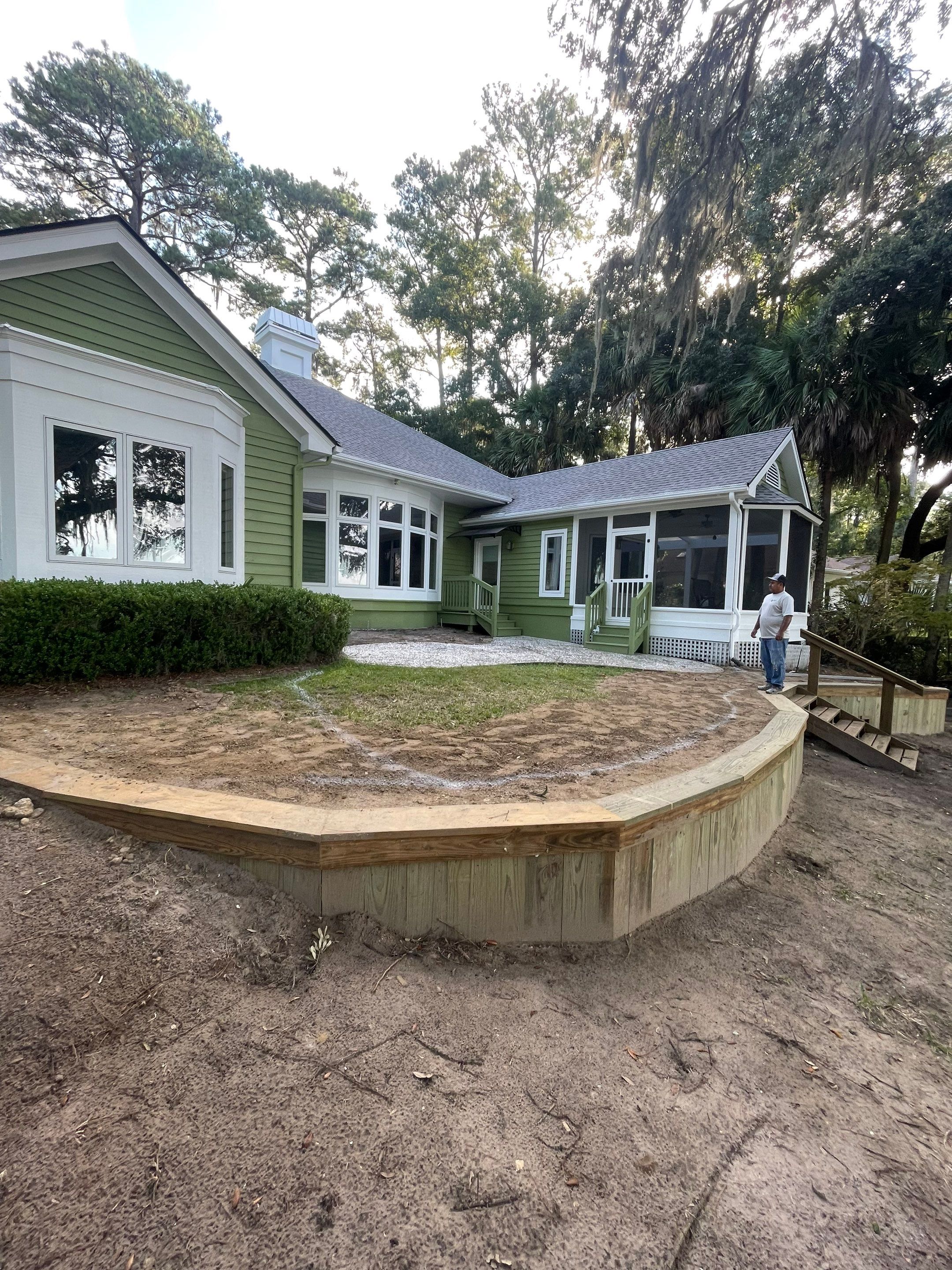 Exposed Aggregate Patio with Brick Inlays and Retaining Wall in Okatie by Lowcountry Scapes, LLC