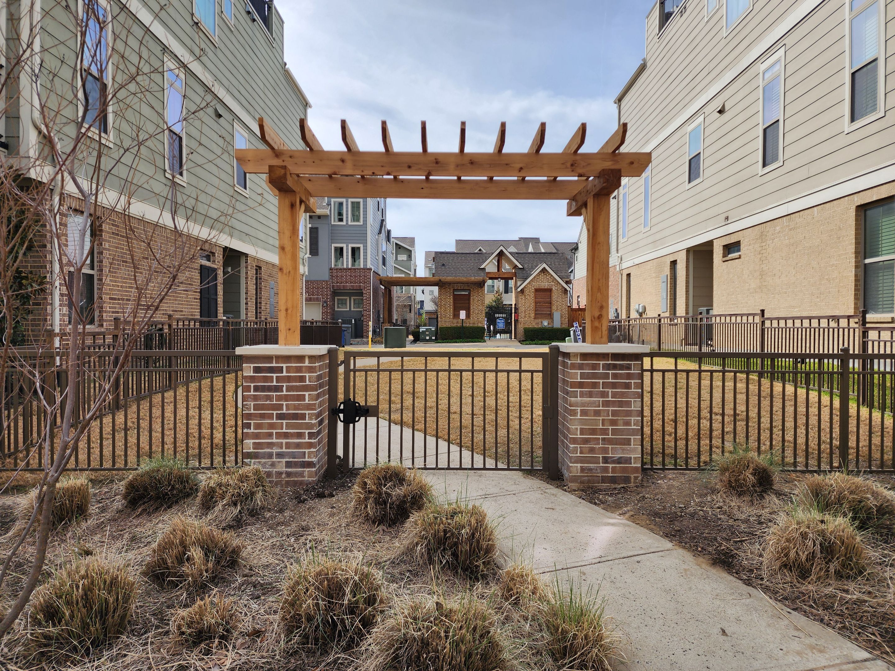 Arbor with Wrought Iron Fencing by 3:16 Roofing and Construction