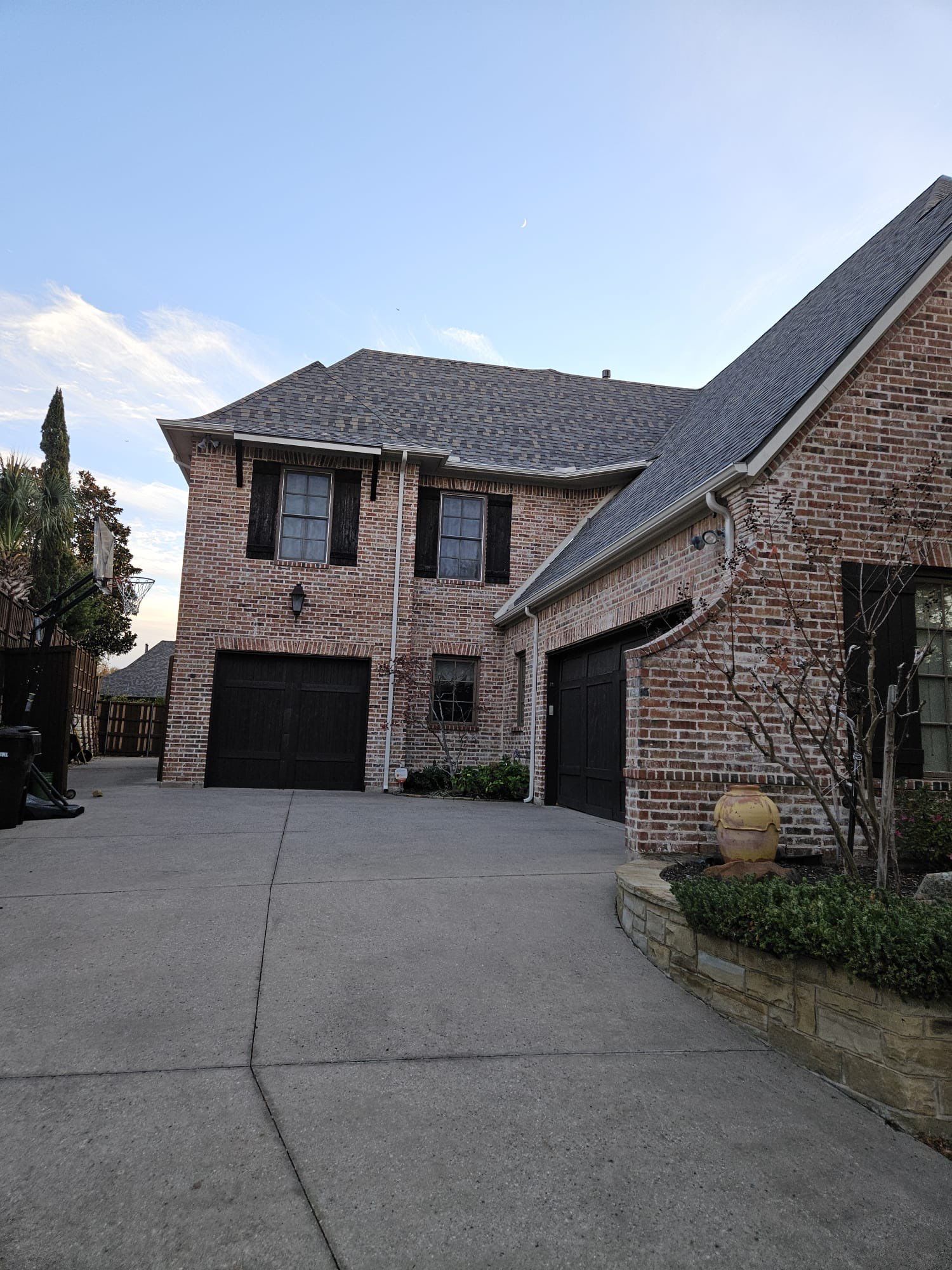 Light red brick/cream stone/espresso shutters with IKO Cornerstone by Tejas Roofworks + Restoration