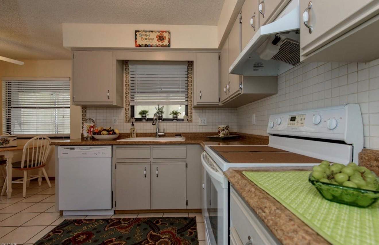 Modern Kitchen Remodel in Port Orange Featuring Waterfall Quartz Island by Acies Renovations