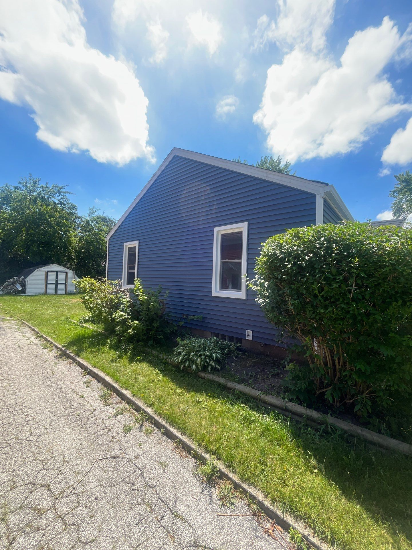 Blue Vinyl Siding and Versetta Stone Exterior Remodel in Bay City by Great Lakes Home Design LLC