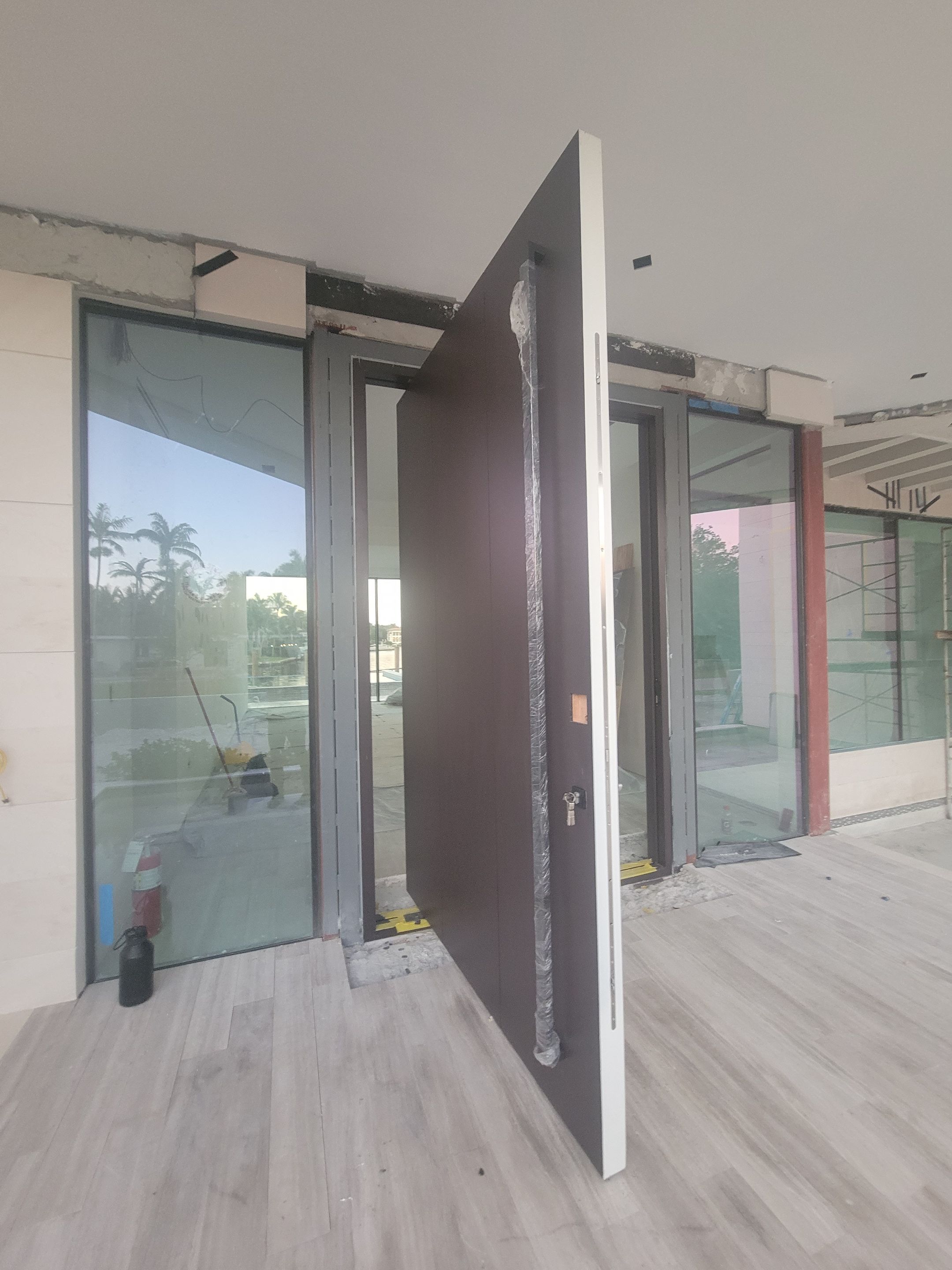 Custom Material Pivot Door installation by Impact Precious Wood Inc.