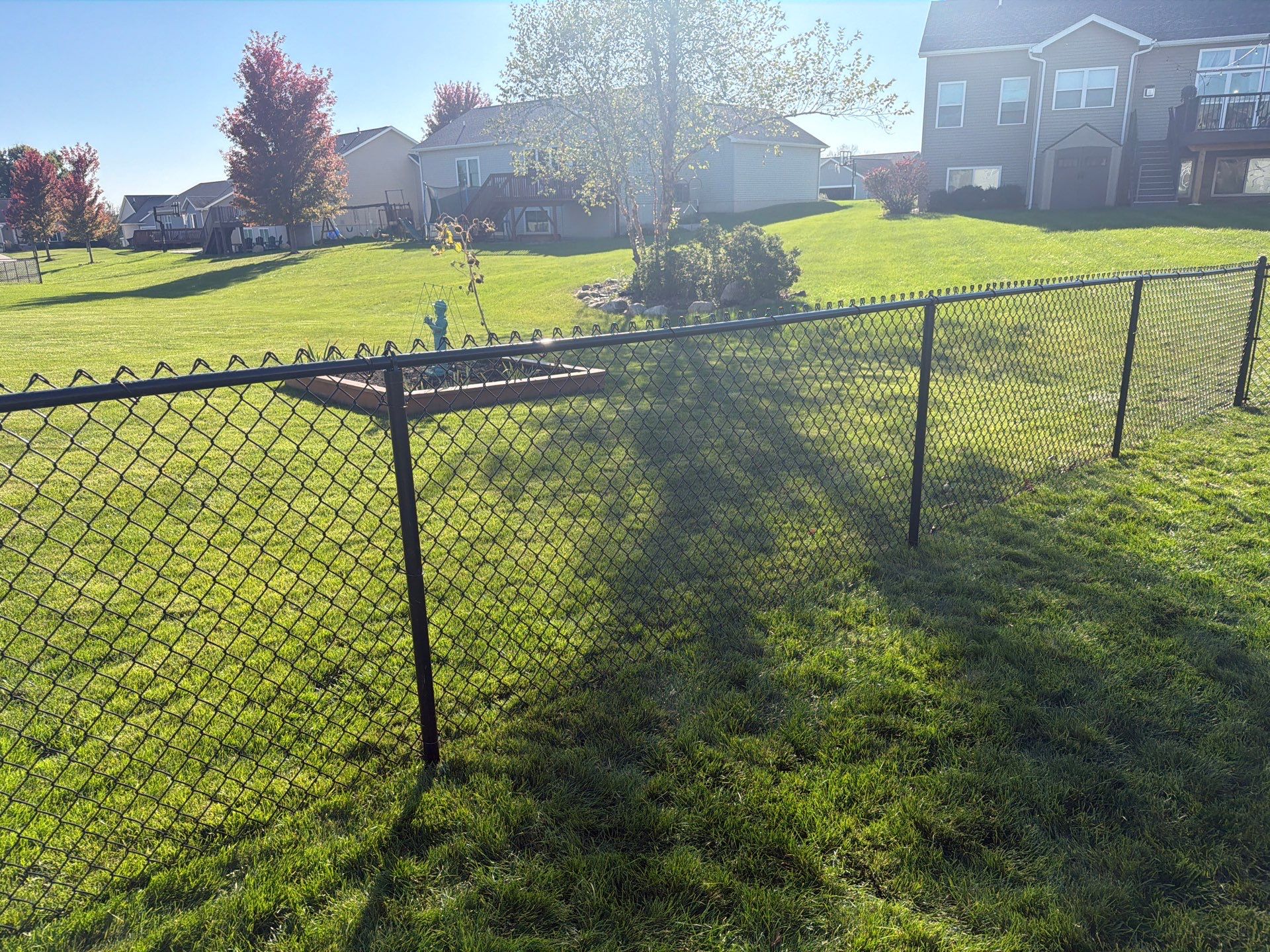 Black Vinyl-Coated Chain Link Fence Installation in Cedar Falls by Perfect Picket Fence and Stain
