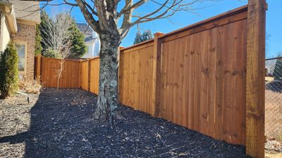 Fence Installation of Capped Wood Privacy Fence using 6X6 posts and copper post caps.