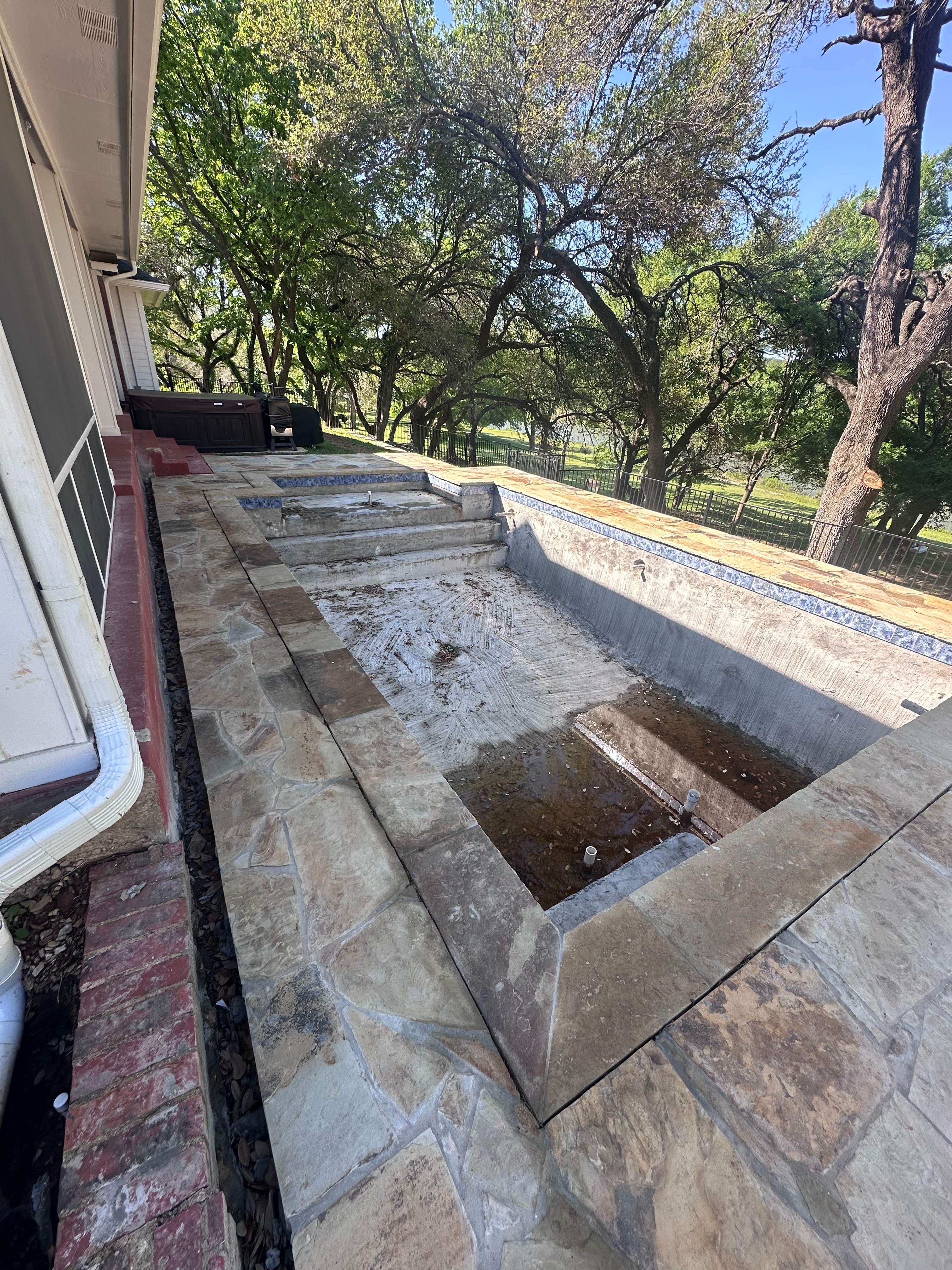 Geometric Pool with Raised Stone Wall and Flagstone Decking by Pinnacle Pools and Spas - DFW