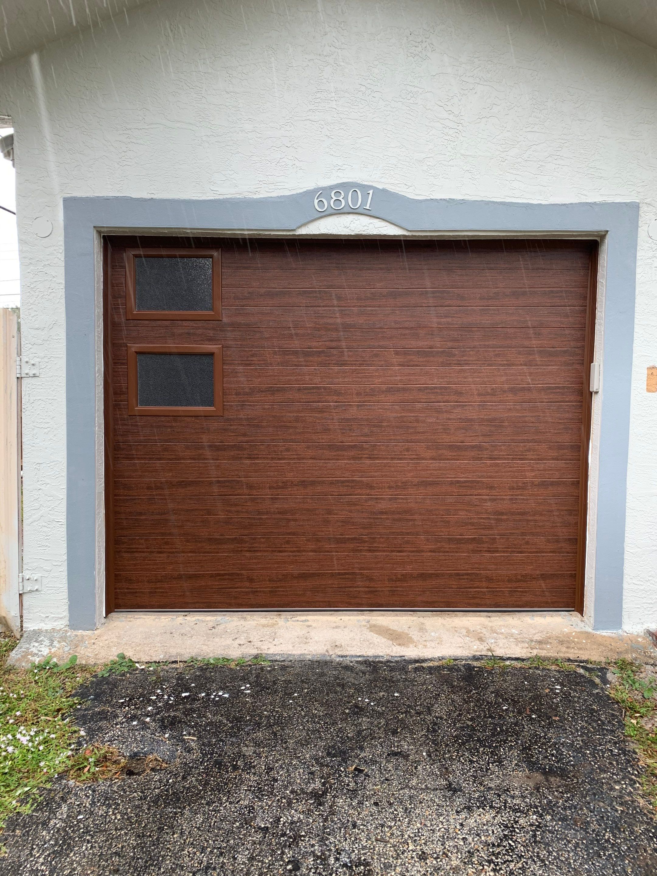 Sectional Garage Door Installation with Wood-Grain Finish in Sunrise - Clopay Modern Steel by The Door Doctor of South Florida, Inc.