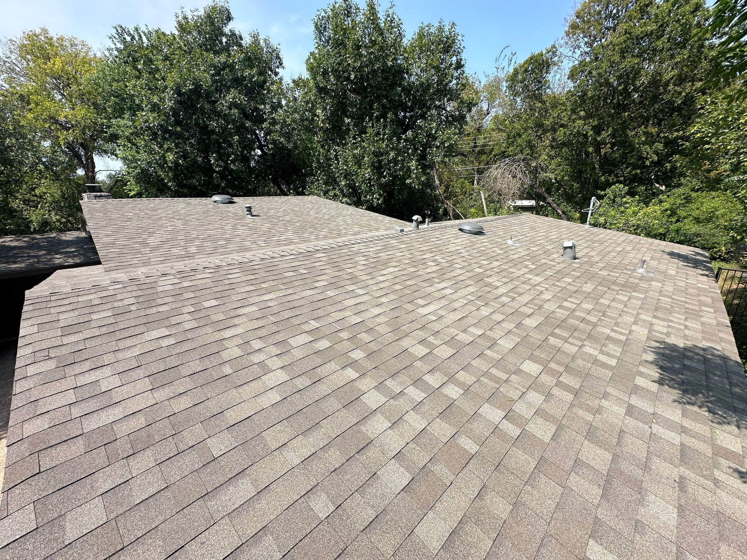 Driftwood Oakridge Roofing Around an Austin Stone Chimney by Skywall Construction LLC
